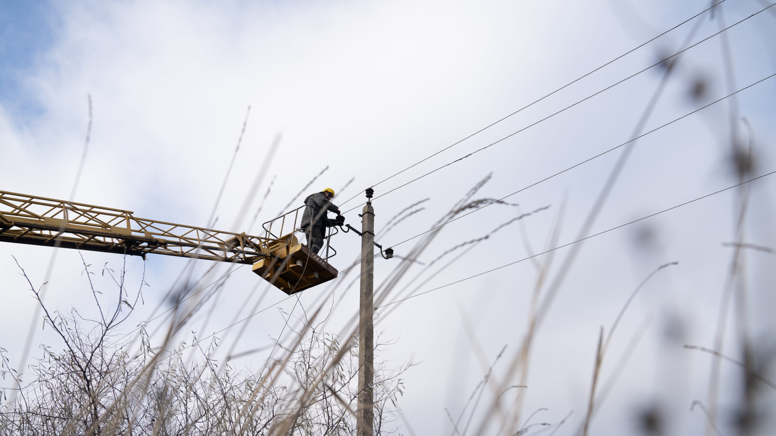 Utility workers north of Lyman, Ukraine, work on restringing electrical poles in an effort to brace the country's energy