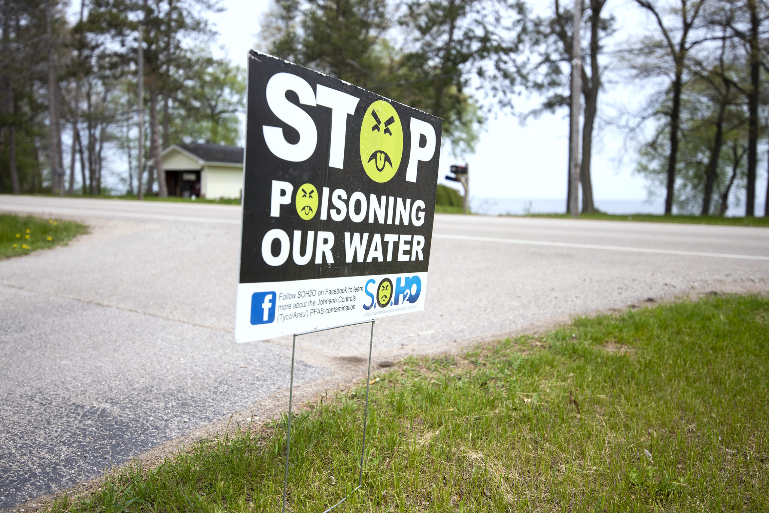 A yard sign says "Stop poisoning our water."