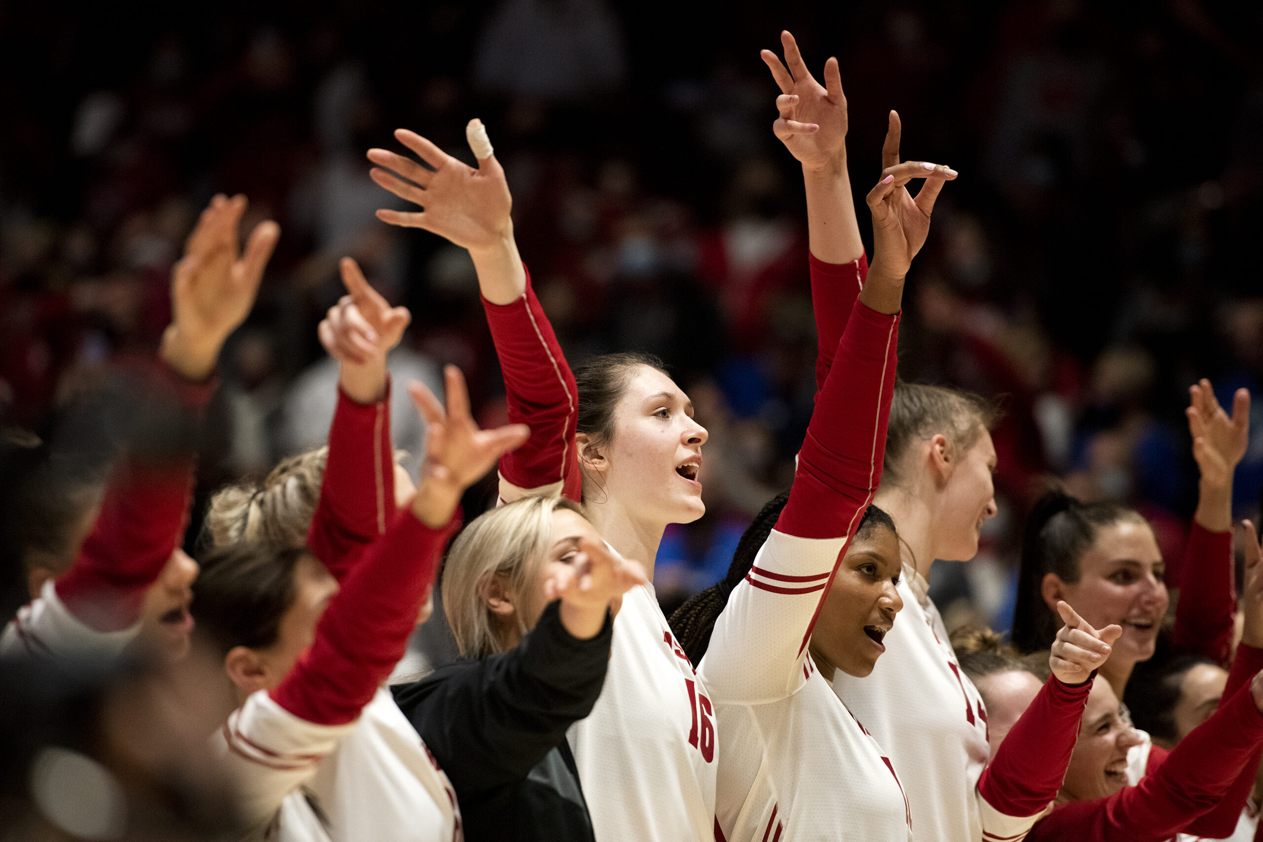 The Wisconsin team raises their arms as they line up on the court after the match.