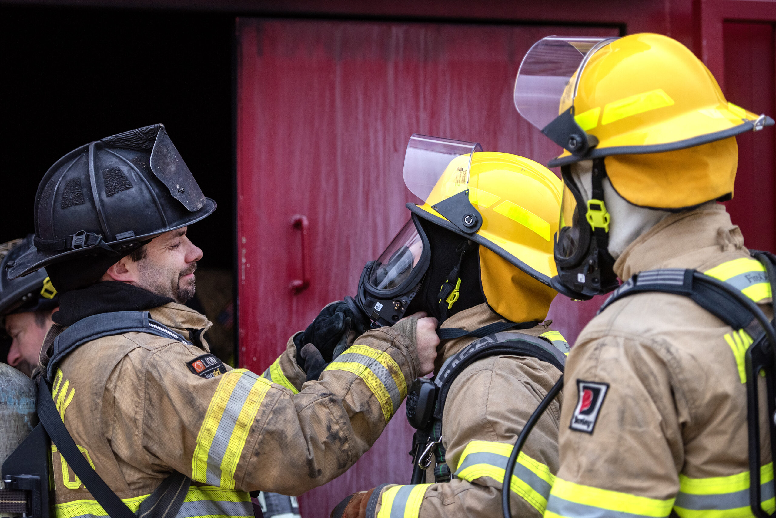 An instructor adjusts a student's mask.