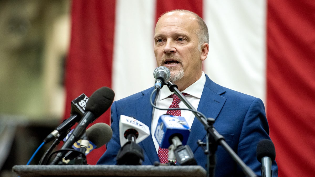 A vertical US Flag is seen behind Brad Schimel as he speaks.