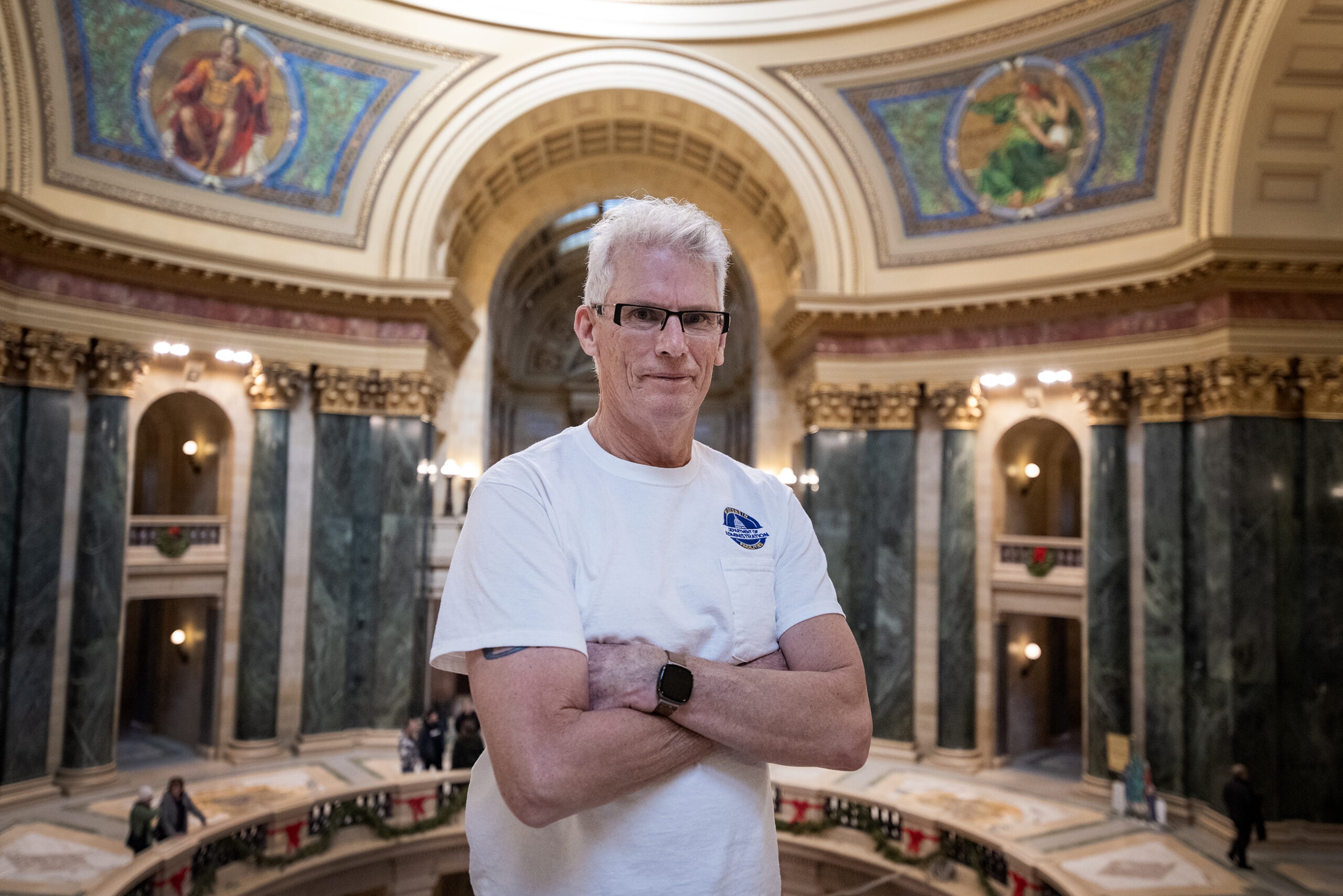 Jeff LaMay stands with his arms crossed. Decorative Capitol details can be seen behind him.