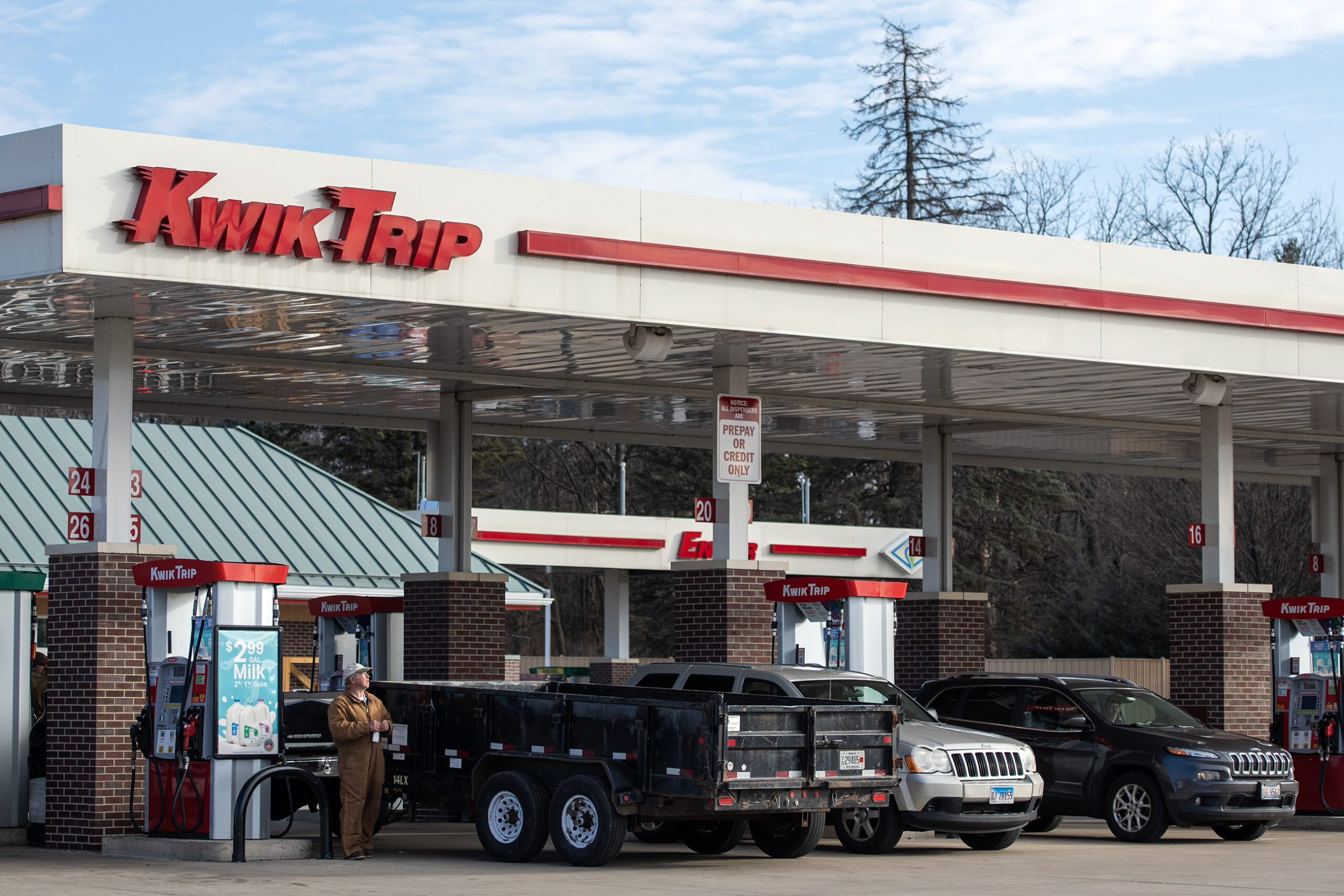 A driver stands outside as he pumps gas at a Kwik Trip.