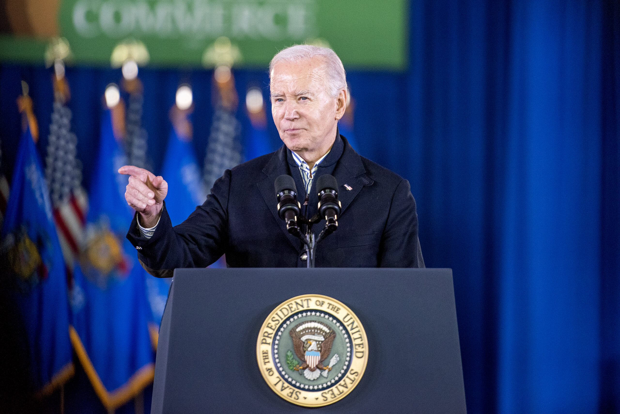 Biden points as he stands at the podium.