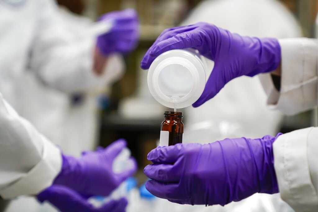 Eva Stebel, water researcher, pours a water sample into a smaller glass container for experimentation as part of drinking water and PFAS research at the U.S. Environmental Protection Agency Center For Environmental Solutions and Emergency Response