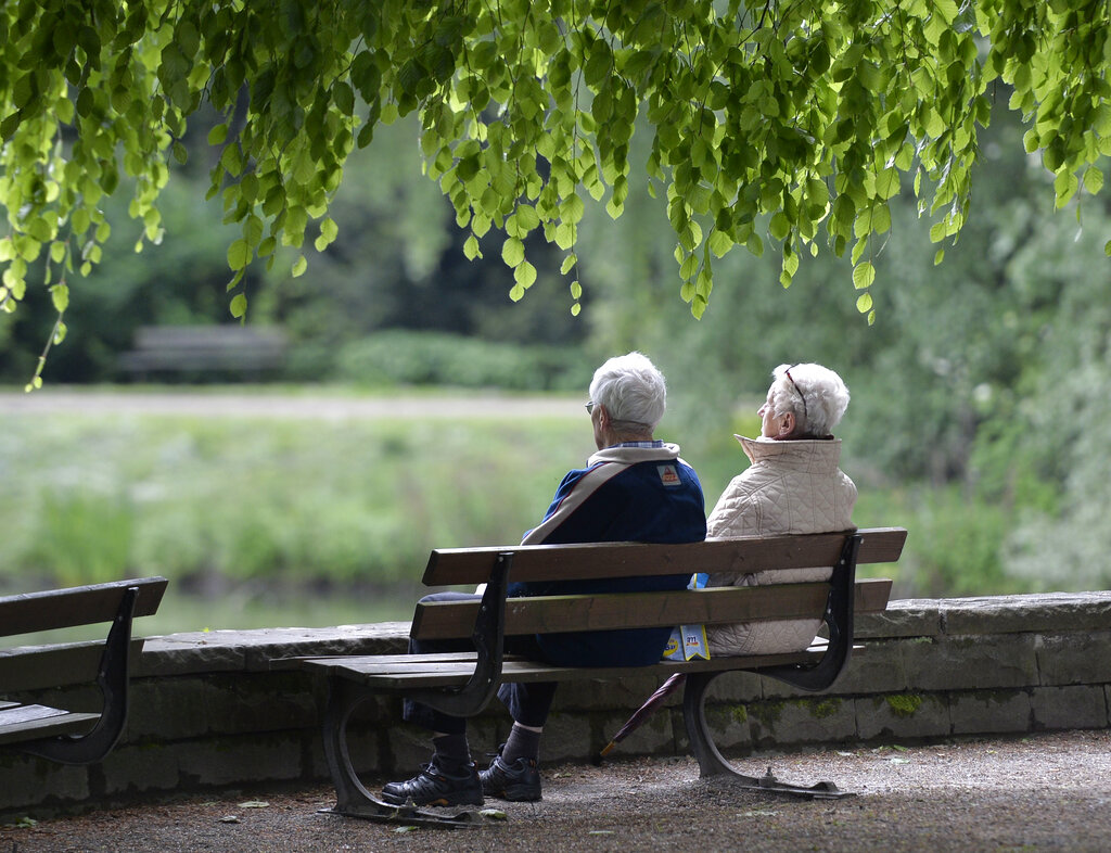 In this May 14, 2014 file photo an elderly couple sits on a bench in a park in Gelsenkirchen, Germany. Getting older isn't all that bad. That's the view taken by more than four in five American seniors, according to a survey that compared attitudes to agi