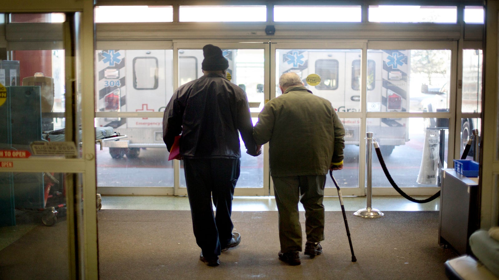 a patient at right is assisted while walking out of the emergency department at Grady Memorial Hospital, in Atlanta