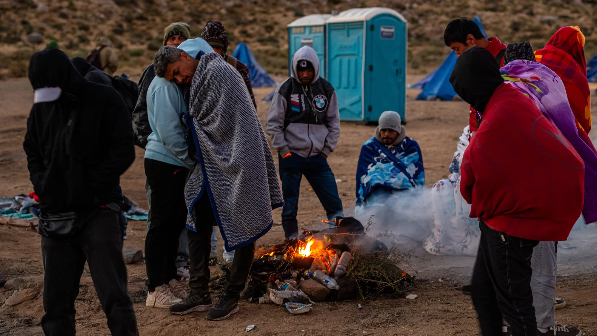 Migrants huddling for warmth at an unofficial detention camp in Jacumba, Calif.