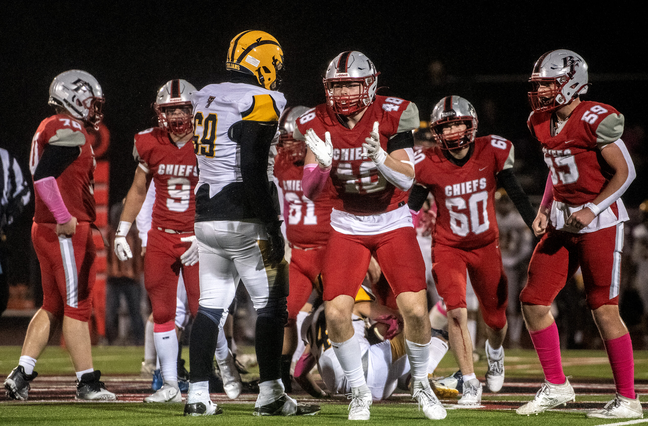 Football players clap their hands after a play.