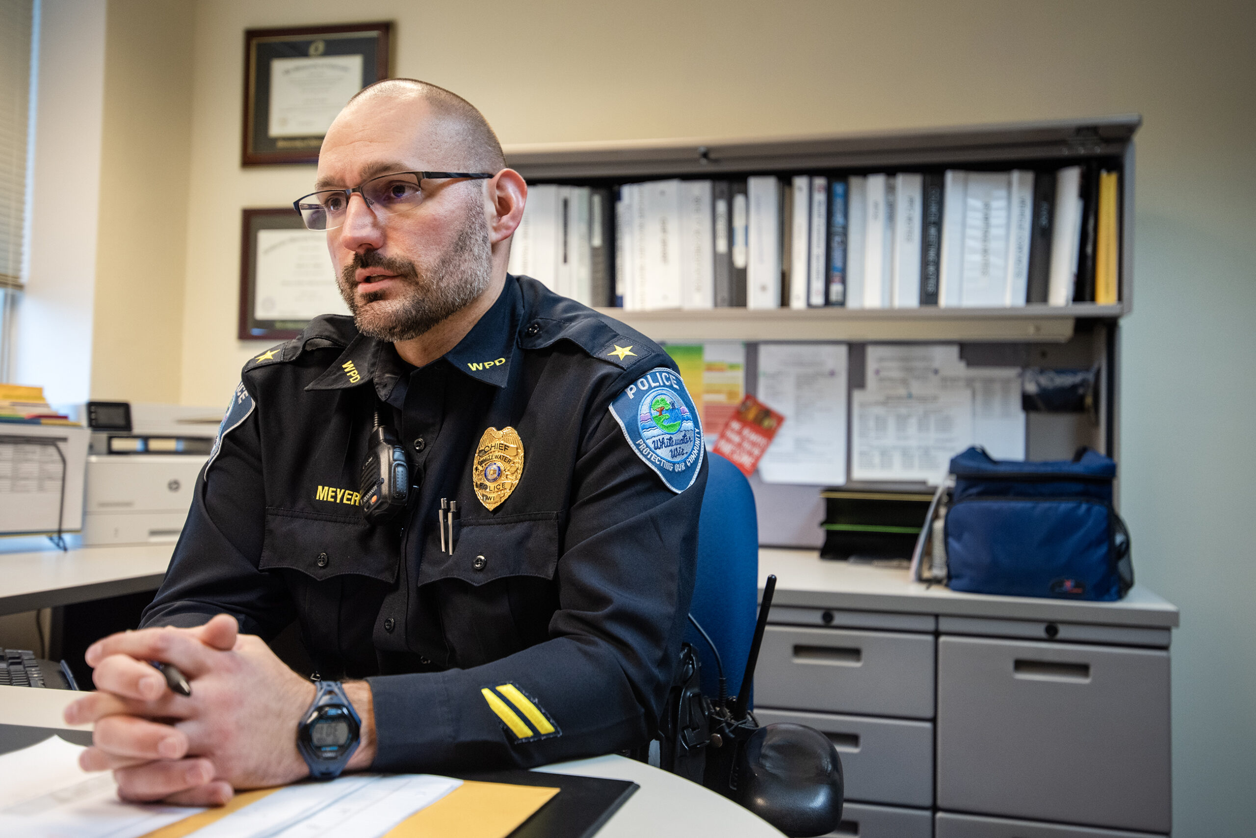 Chief Meyer clasps his hands as he sits at his desk.