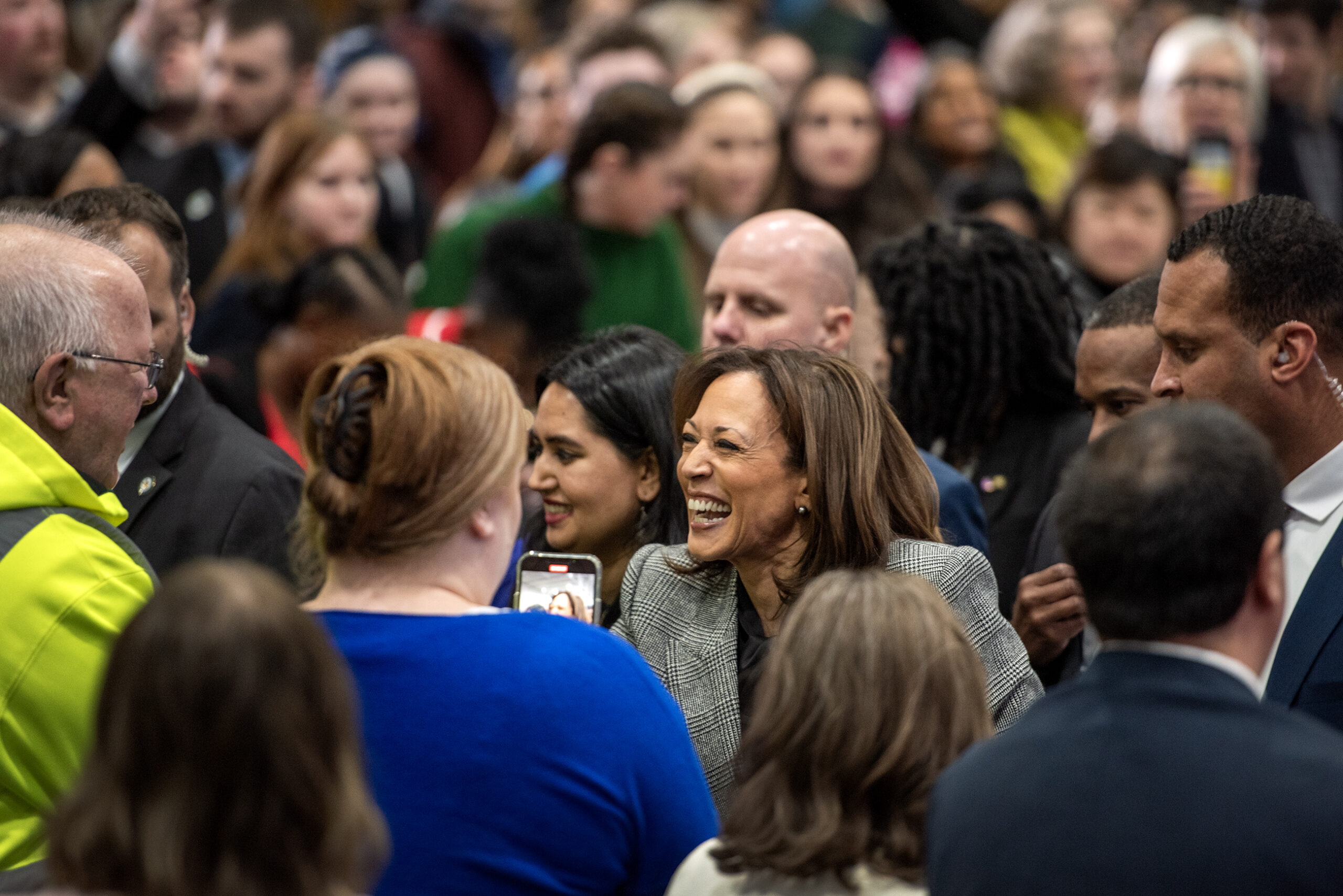 VP Harris smiles as she greets a crowd of people.