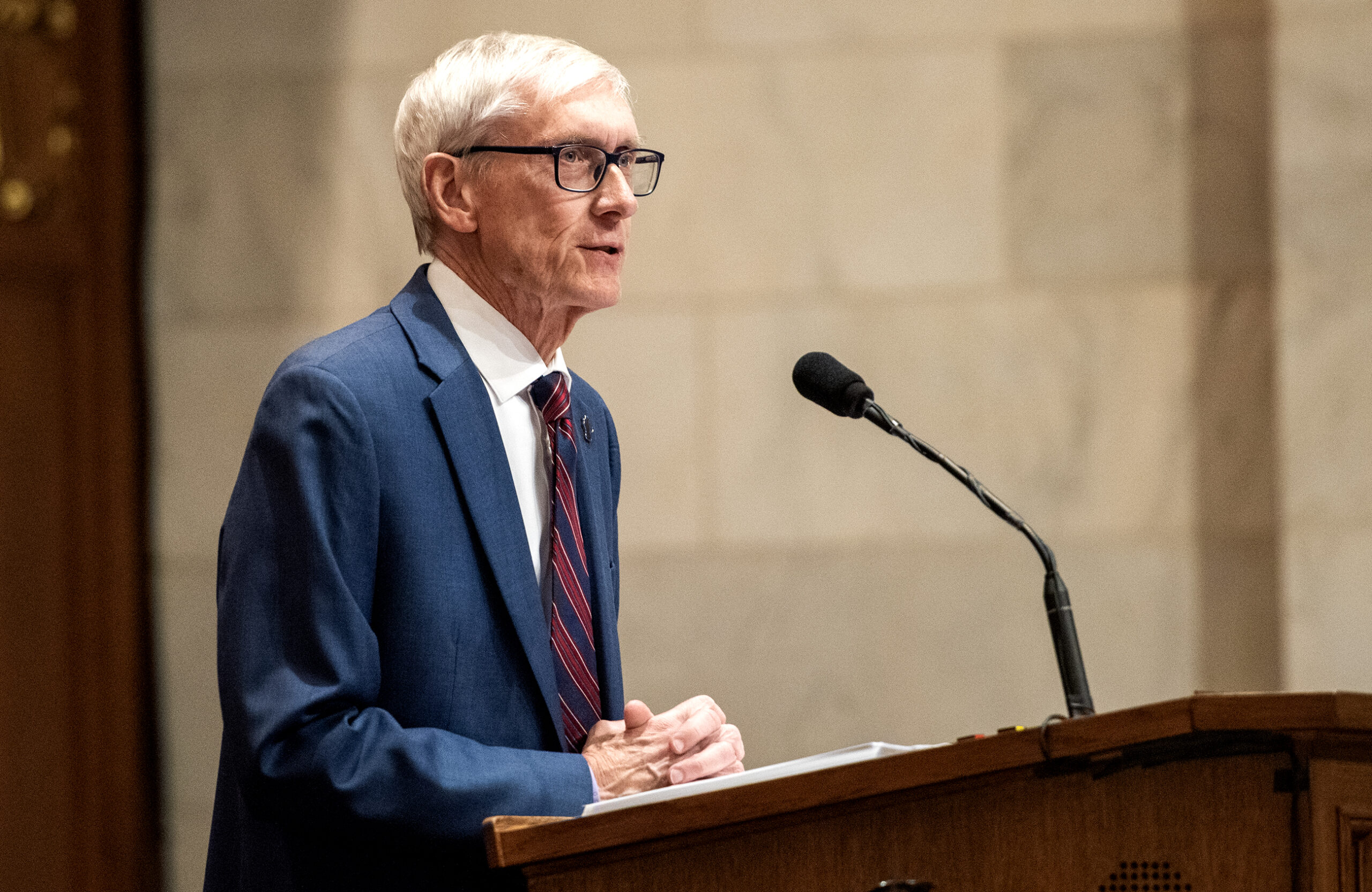 Gov. Evers looks forward as he delivers an address from the podium.