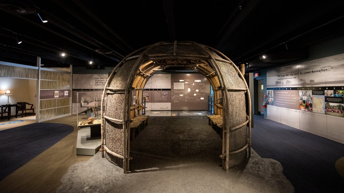 A house with a large entry and exit has a curved appearance as it sits in the middle of the exhibit.