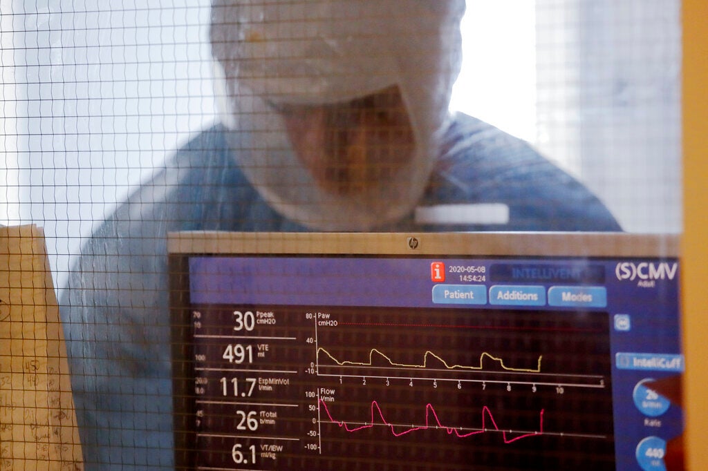 FILE - In this May 8, 2020, file photo a nurse works inside a patient's room in the COVID-19 Intensive Care Unit at Harborview Medical Center in Seattle. People are still more likely to prefer the private sector than the government on driving innovation i