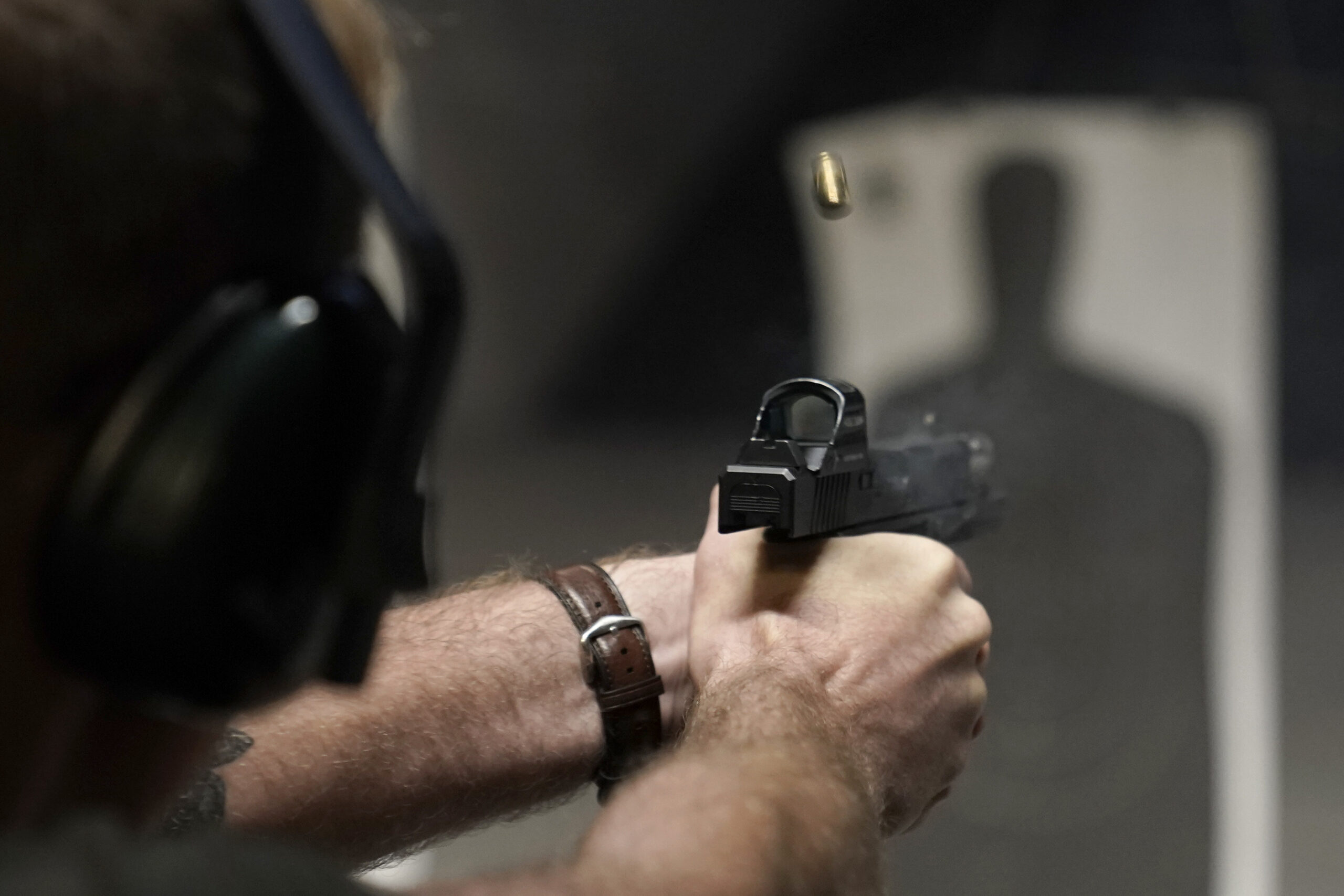 Someone fires a handgun at a shooting range