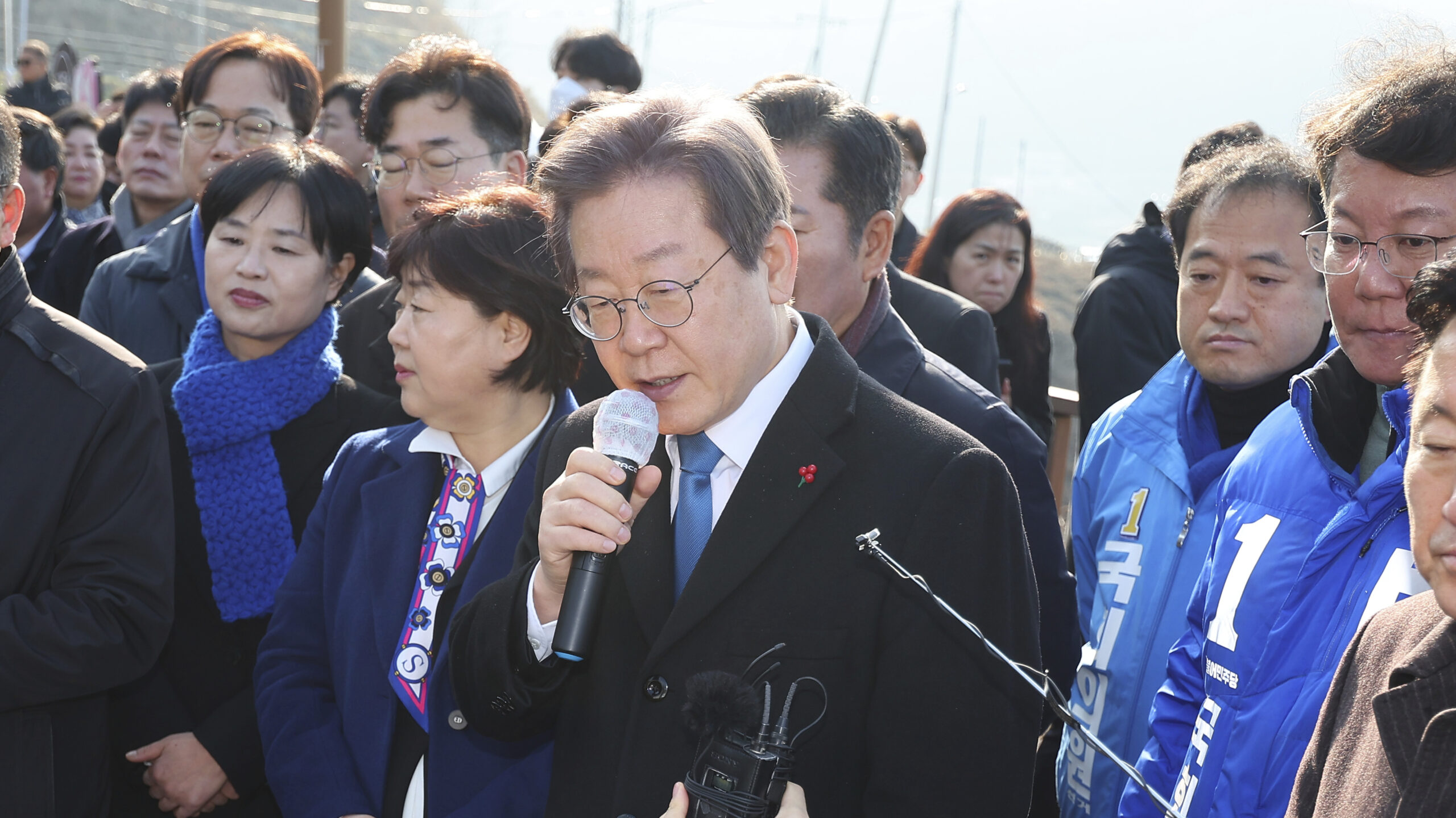 South Korean opposition leader Lee Jae-myung, center, speaks as he visits the construction site of a new airport in