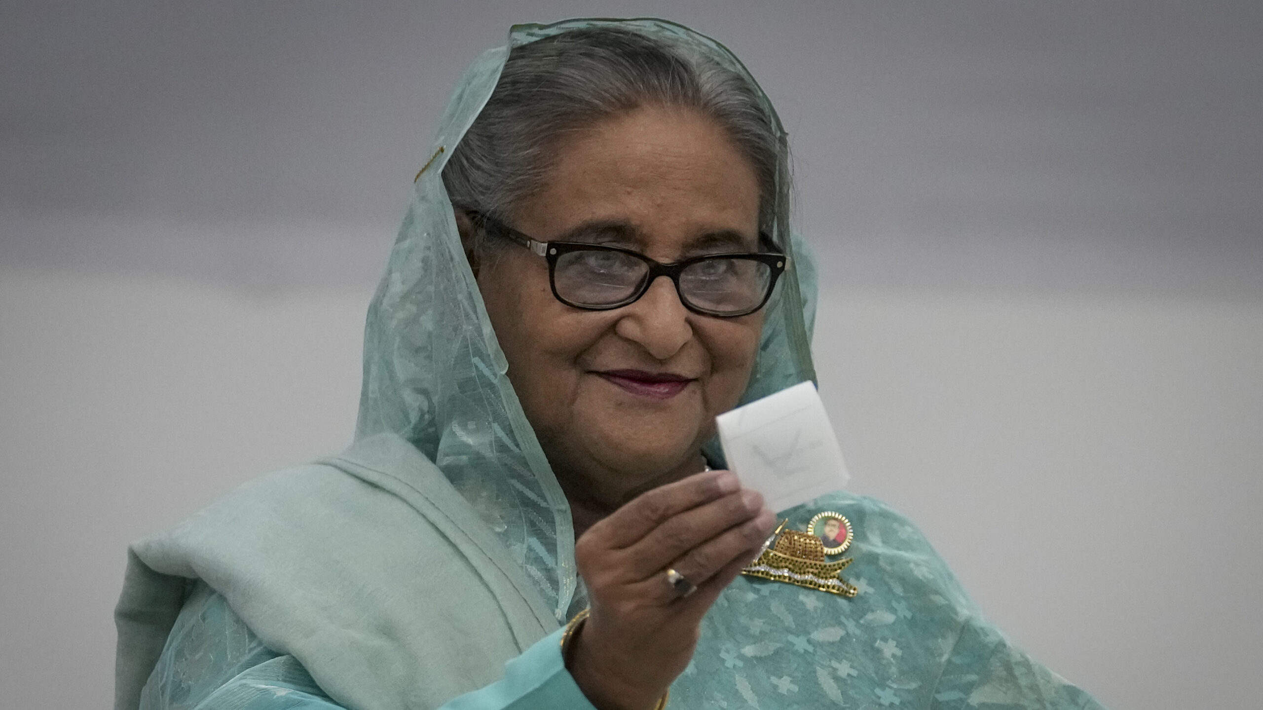 Bangladesh Prime Minister Sheikh Hasina shows her ballot paper as she casts her vote in Dhaka, Bangladesh, Sunday, Jan.