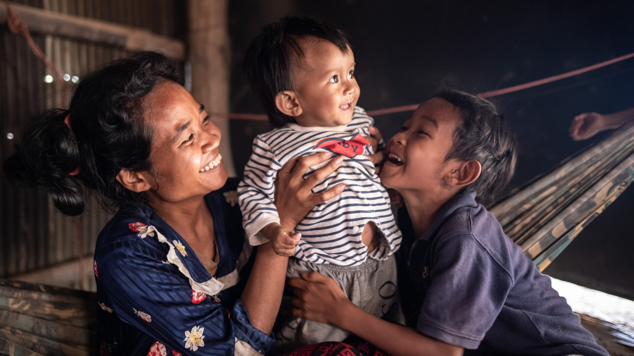 Ten-month-old Ahmin Esas, who was born with clubfoot, shares a moment with his mother and brother in the family's home