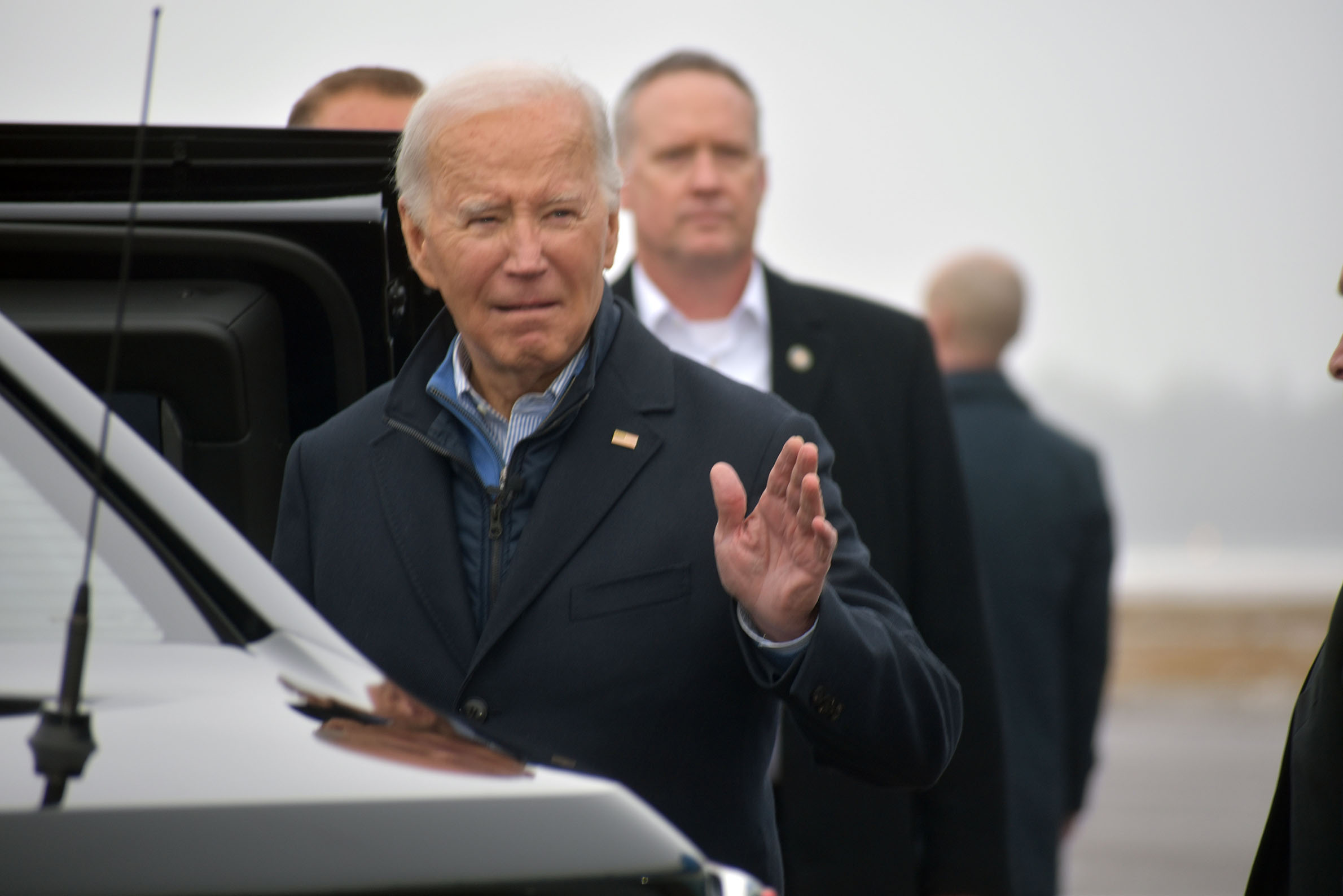 President Joe Biden waves at the press pool as he leaves in the presidential motorcade bound for Superior.