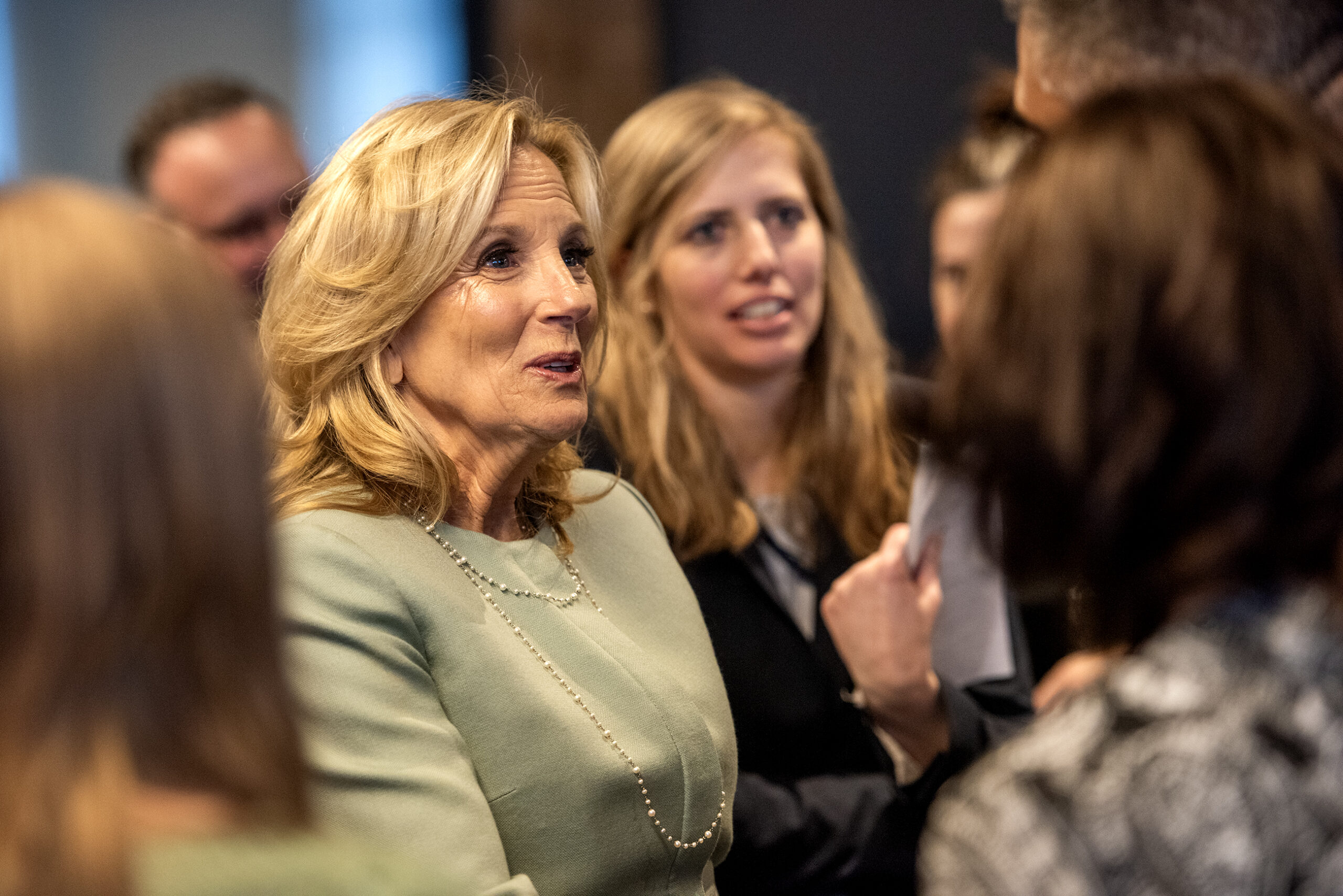 Jill Biden smiles as she shakes hands with people in a crowd.