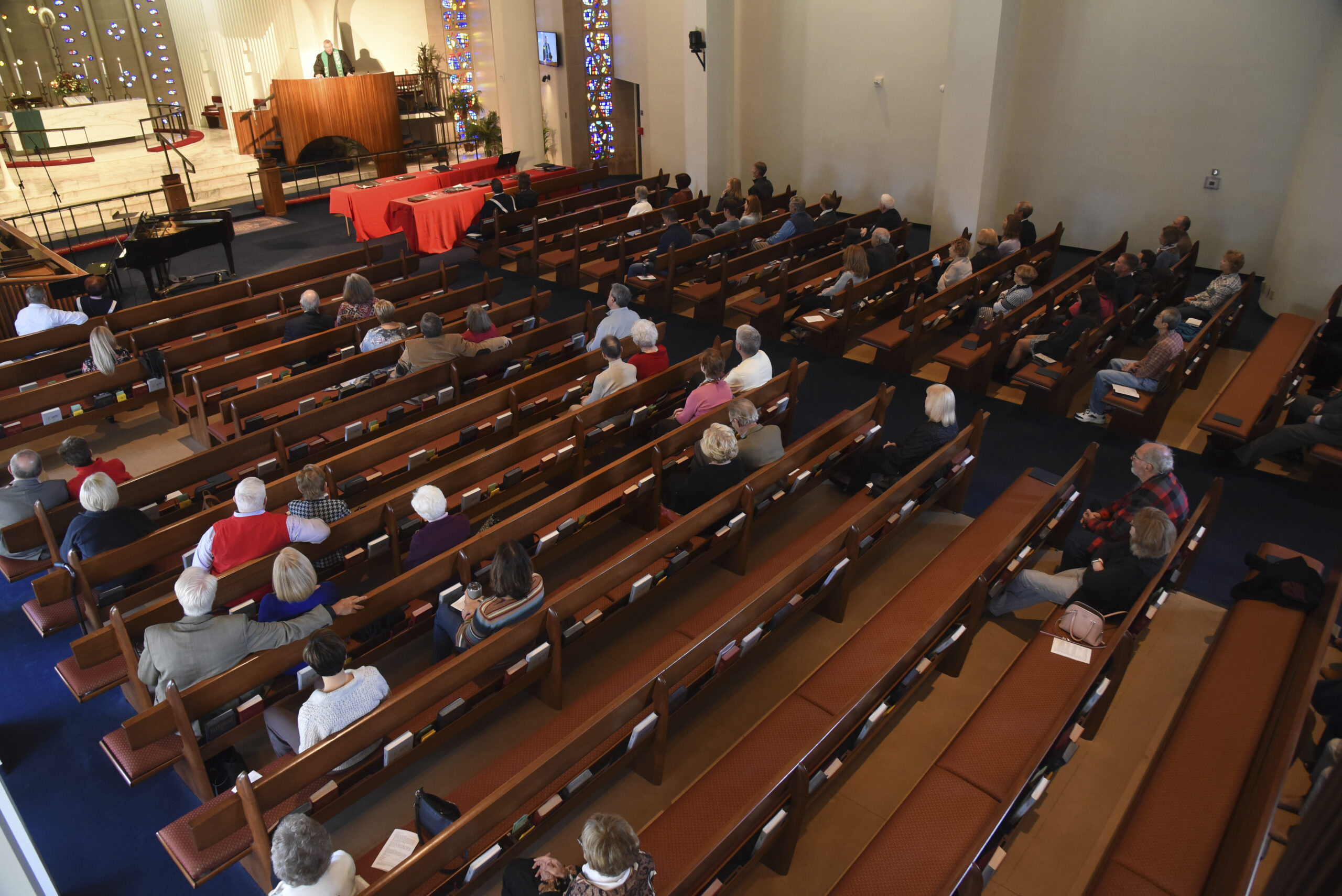 People sit in church pews and listen to Rev. Chris Morgan speak at the front of the church.