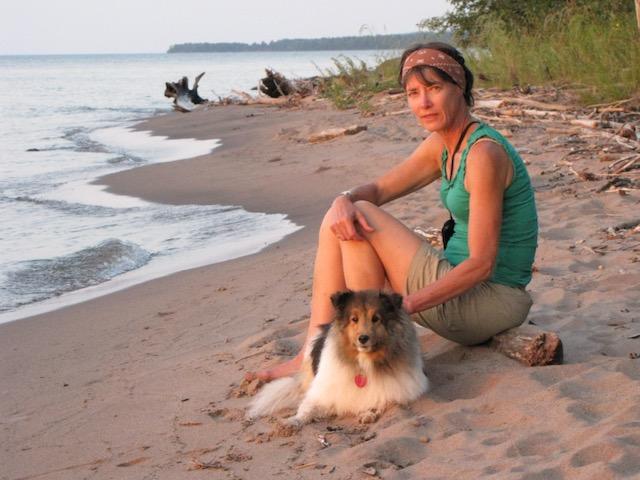 Author Sue Leaf sits with her dog along the South Shore of Lake Superior.