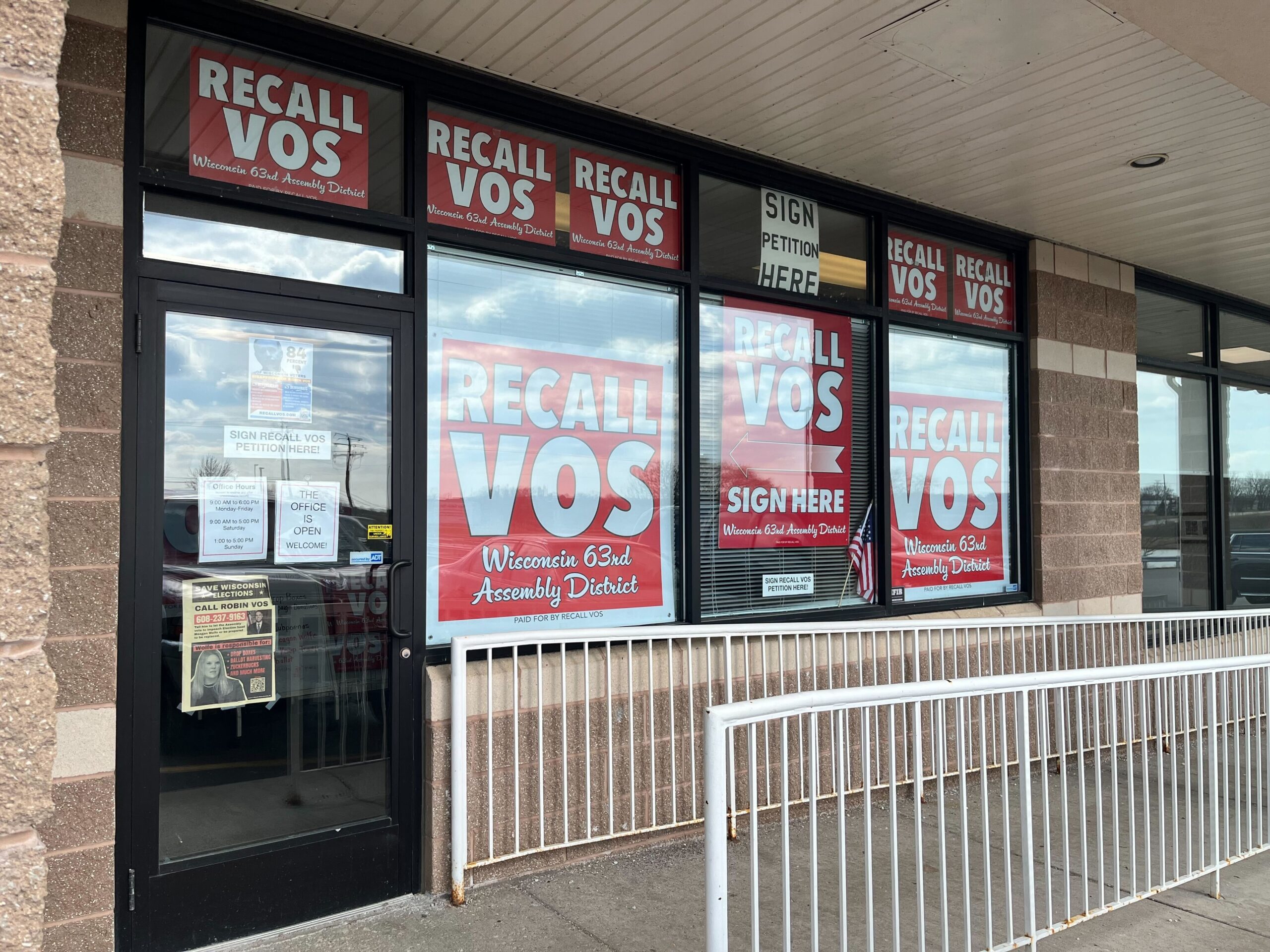 Windows of a storefront have red signs saying "RECALL VOS" in white letters