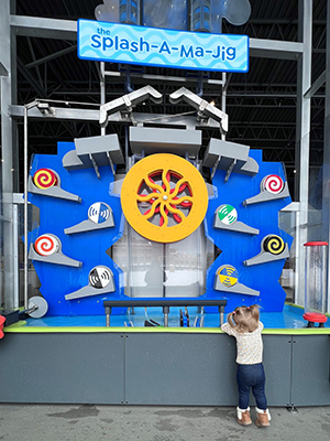 A child plays with an exhibit called the Splash-A-Ma-Jig
