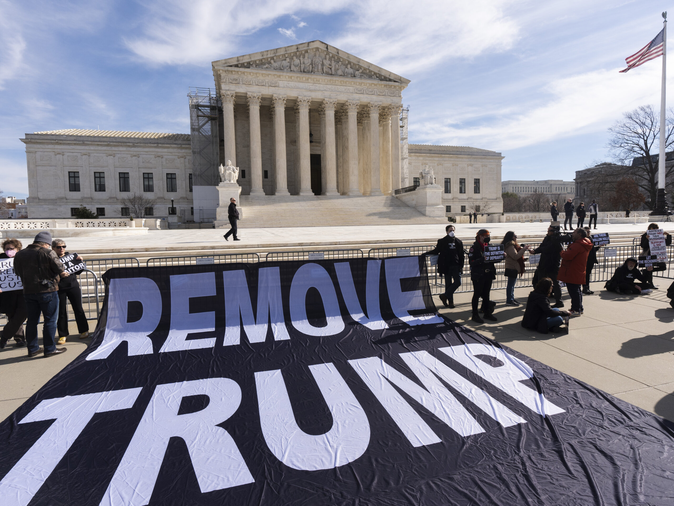 A banner is displayed in front of the U.S. Supreme Court on Thursday, as justices prepared to hear arguments in a case about whether former President Donald Trump can be disqualified from state ballots. The case has profound implications for the 2024 election.