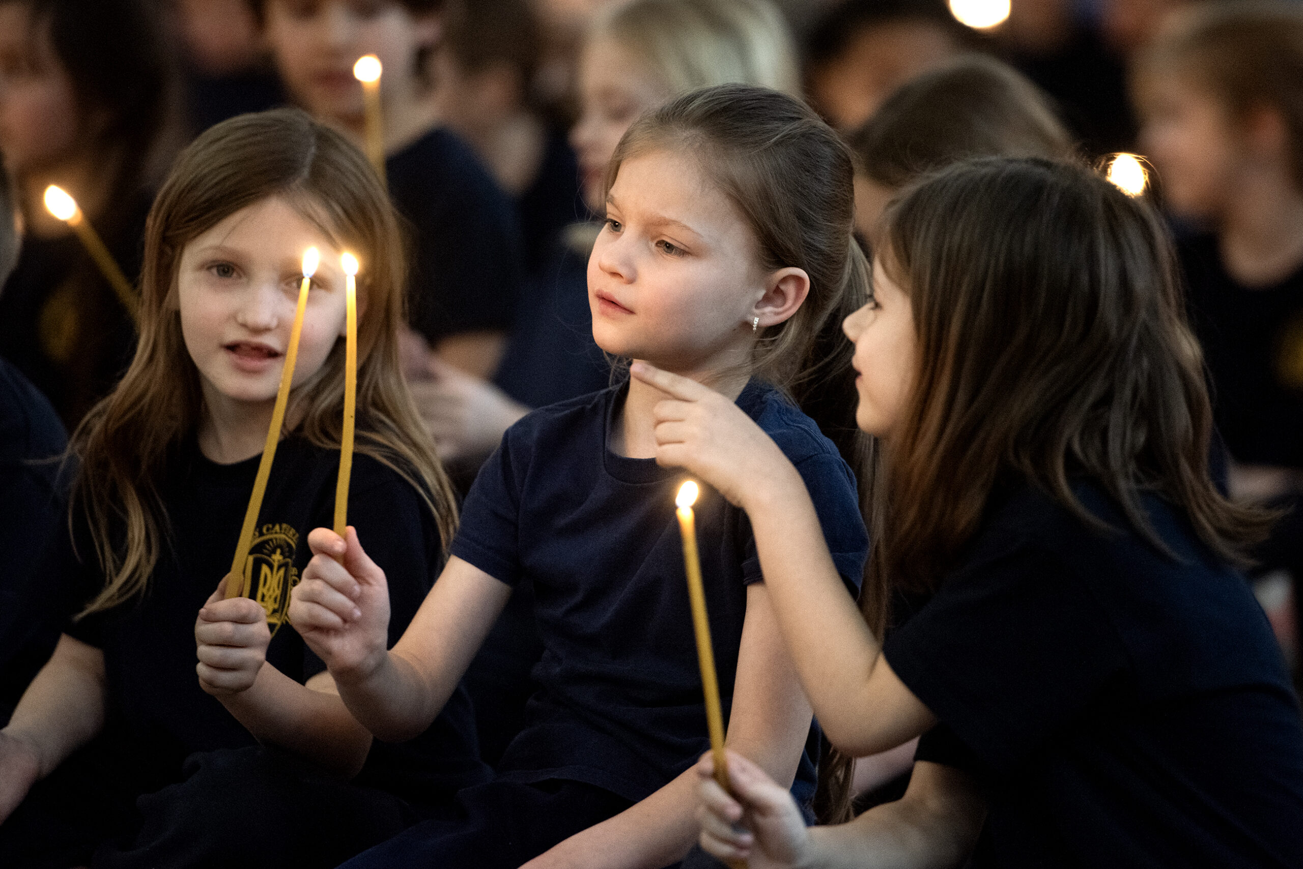 Children sit with lit candles