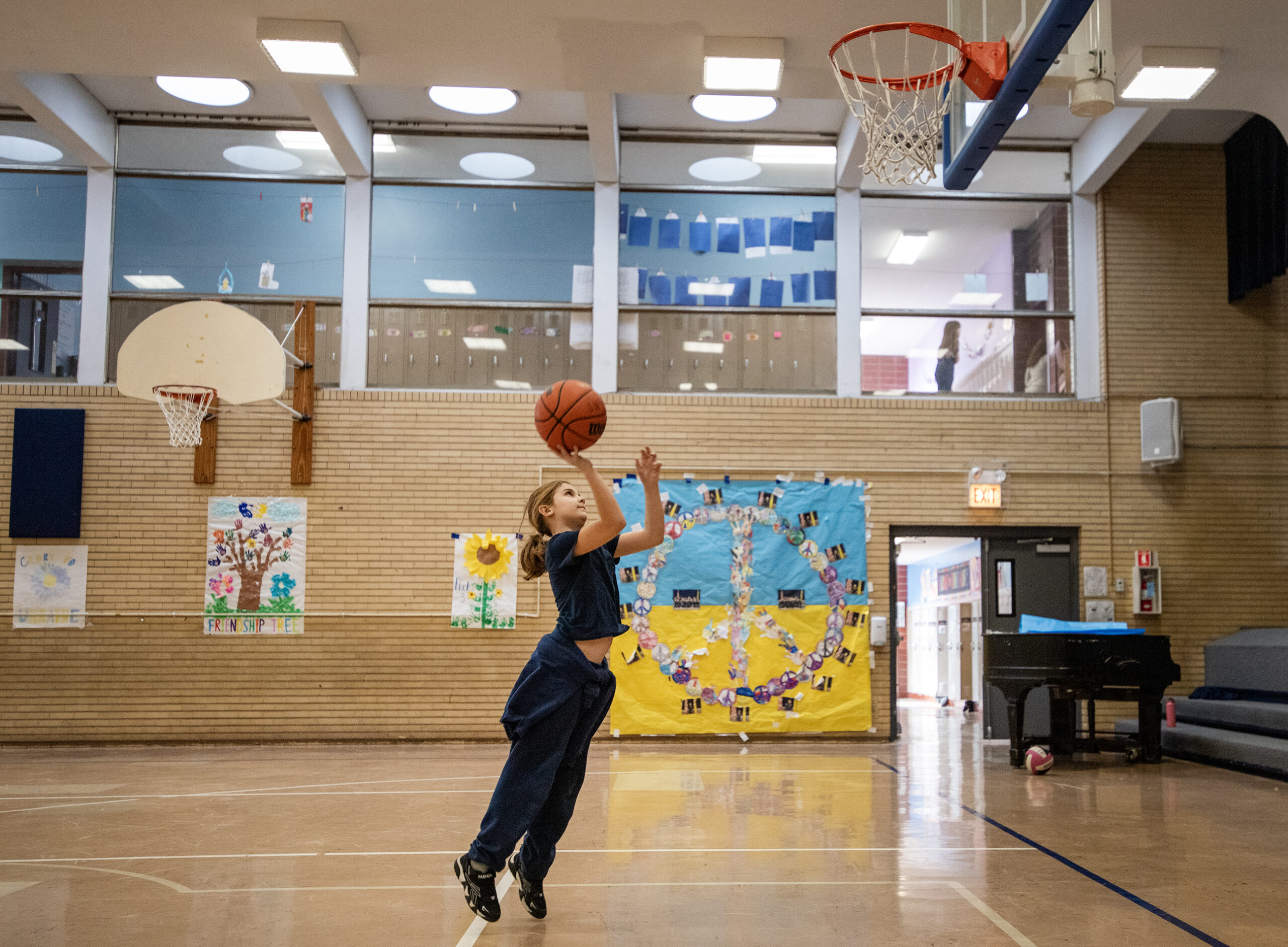 A girl shoots a basketball in a gym.