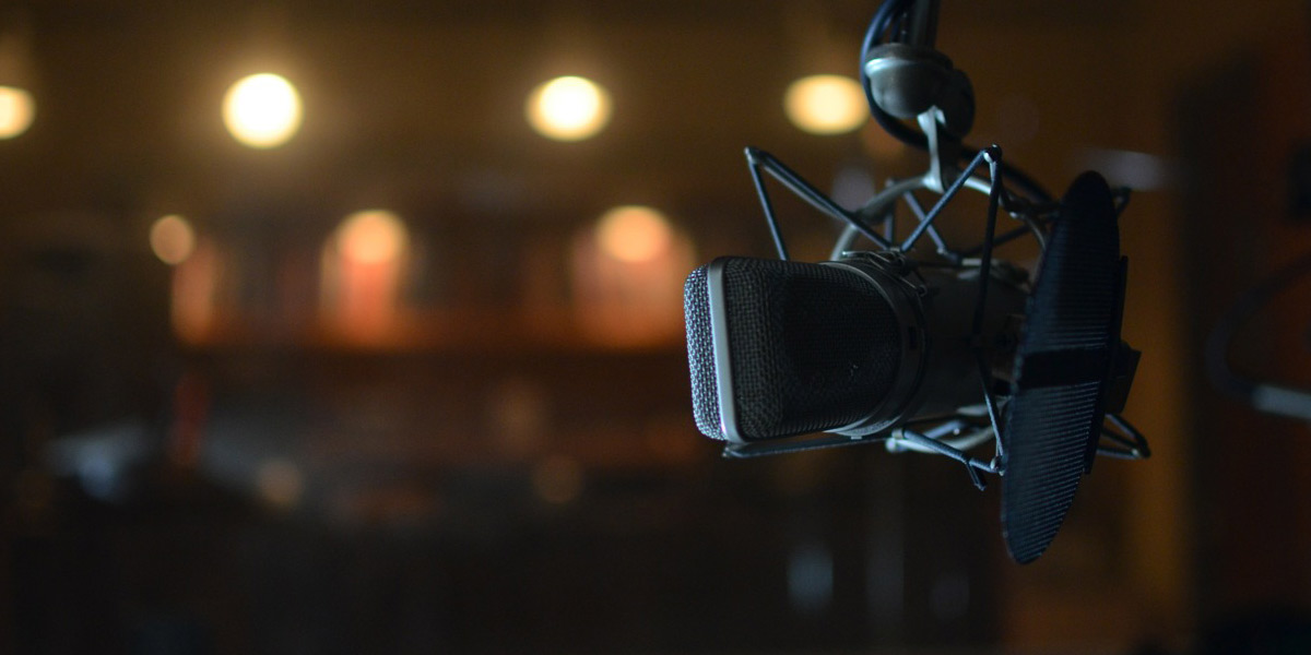 A close up photo of a gray microphone in a dark studio at WPR's headquarters in Madison.