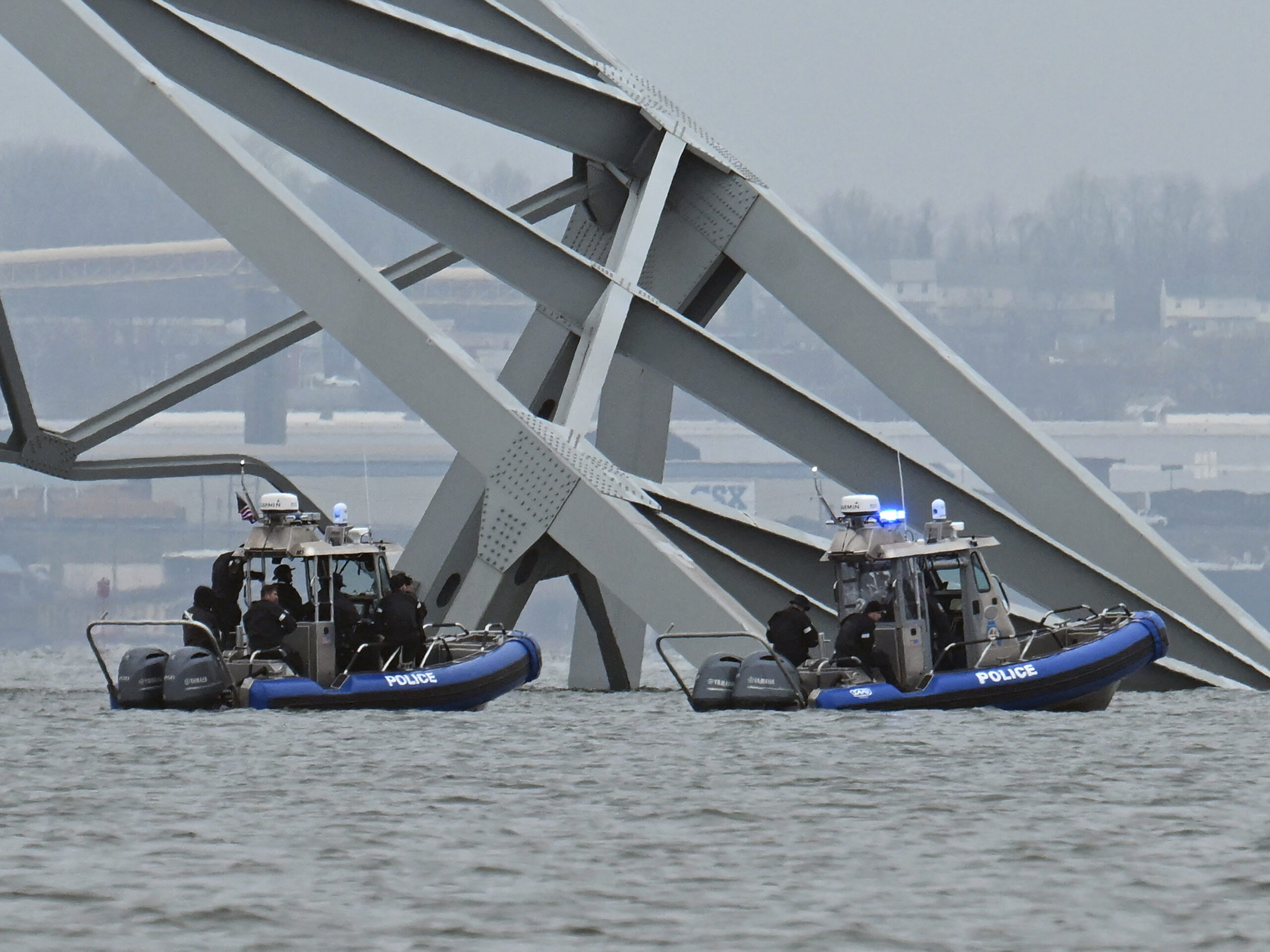 Police recovery crews work near the collapsed Francis Scott Key Bridge after it was struck by the container ship Dali in Baltimore, Maryland.   Eight members of a construction crew repairing potholes were on the bridge when the structure fell into the Patapsco River at around 1:30 am on March 26.