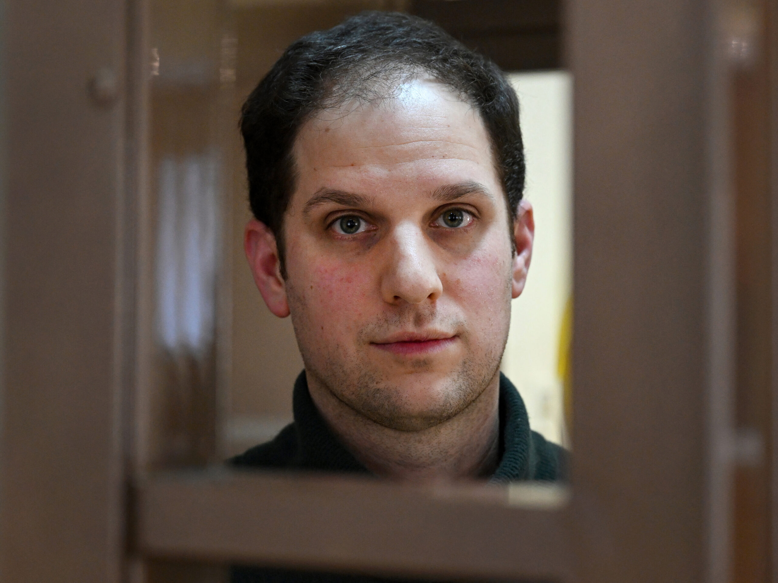 U.S. journalist Evan Gershkovich looks out from inside a defendants' cage before a hearing to consider an appeal on his extended pretrial detention, at the Moscow City Court in Moscow, on Feb. 20.