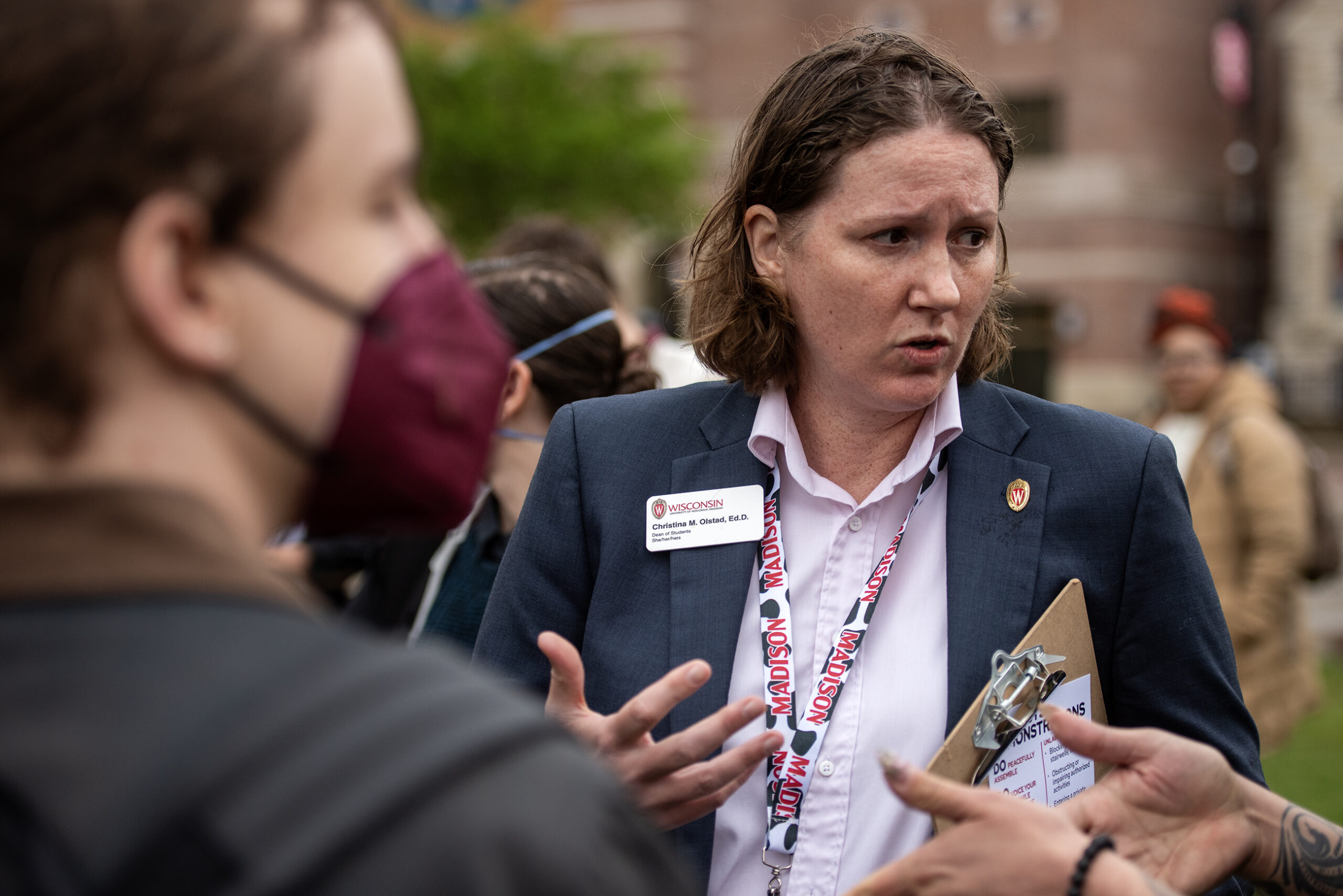 The Dean of Students holds a clip board as she speaks to protesters.