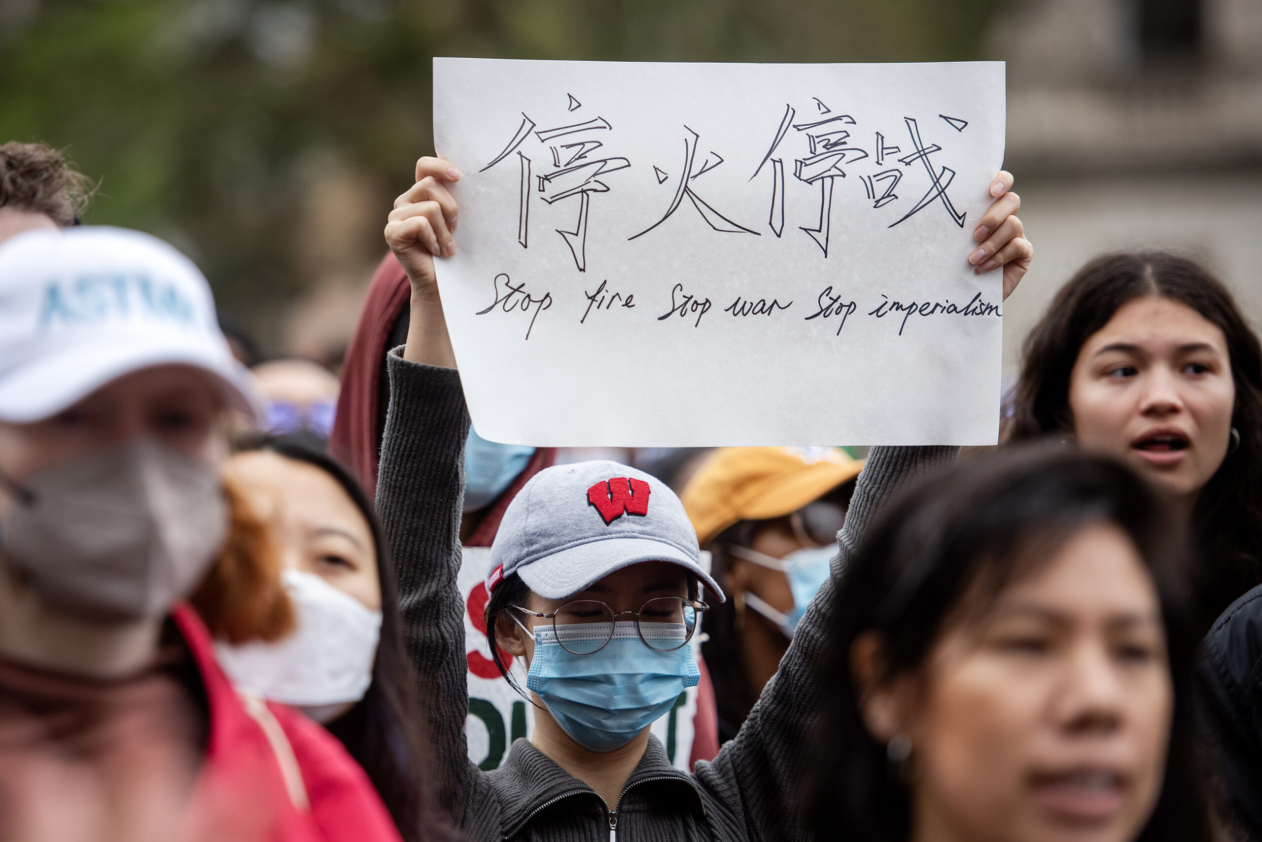 A sign says "Stop Fire Stop War Stop Imperialism"