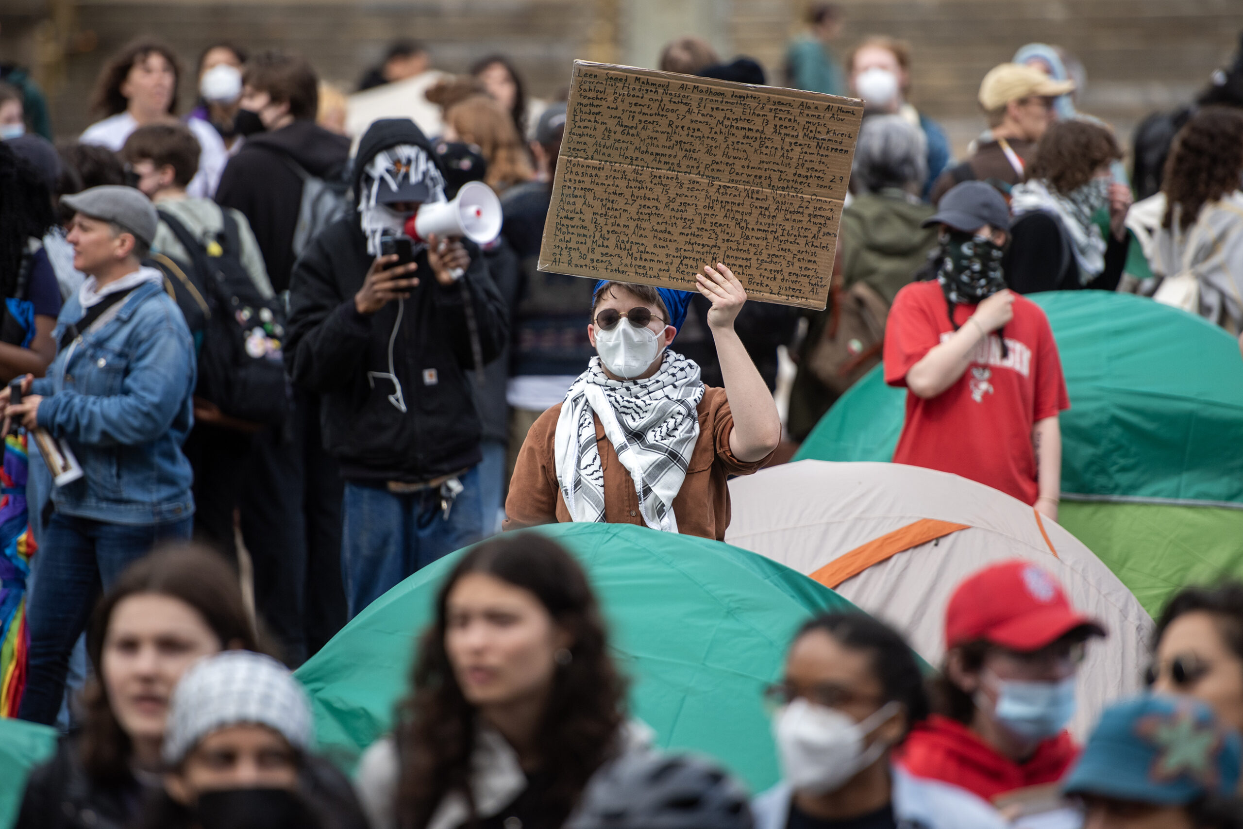 A protester holds a sign with a long list of names.