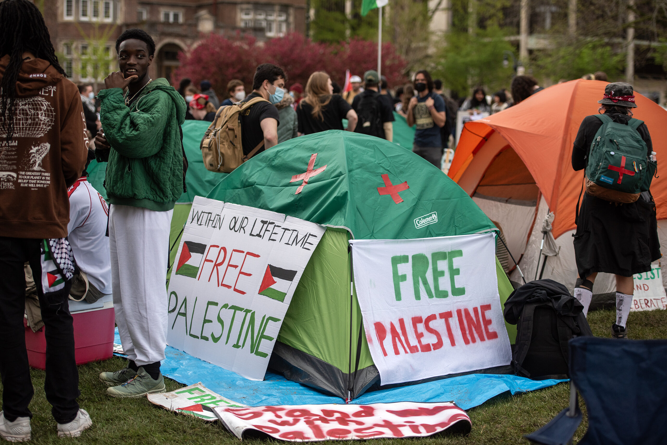 Signs that say "Free Palestine" are displayed outside of a tent.