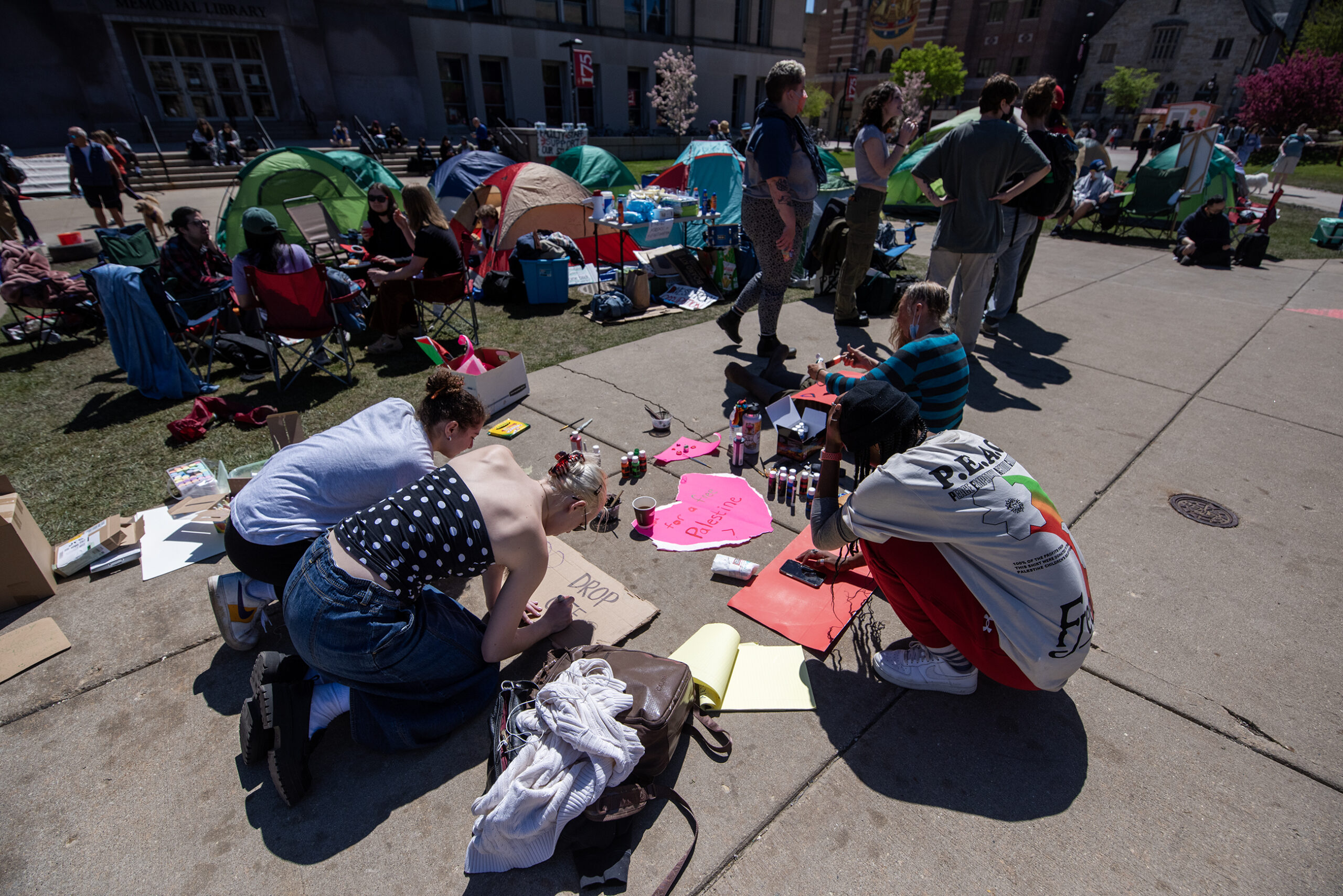 Four people paint signs on the ground.