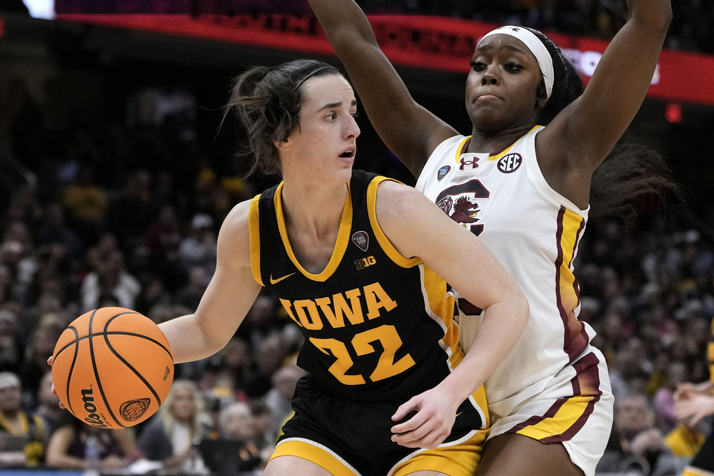 Iowa guard Caitlin Clark (22) drives around South Carolina guard Raven Johnson (25) during the second half of the Final Four college basketball championship game in the women's NCAA Tournament, Sunday, April 7, 2024, in Cleveland.