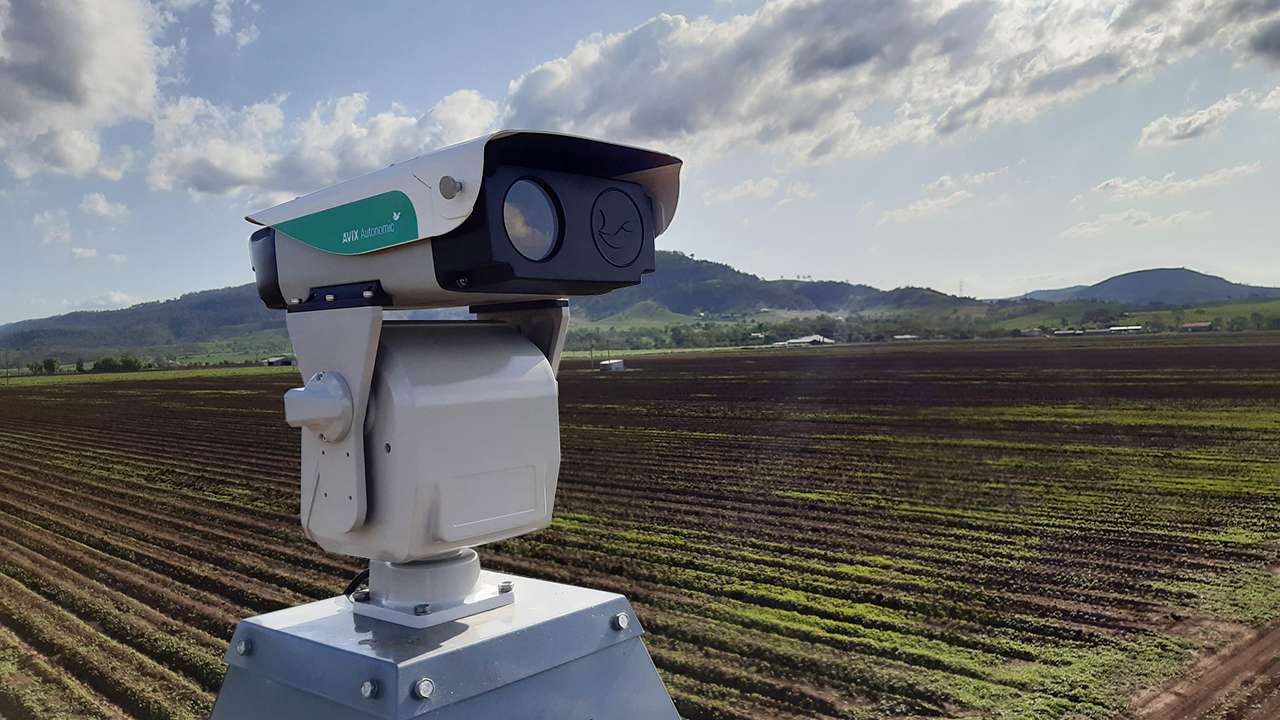 A laser device stands over a farm field