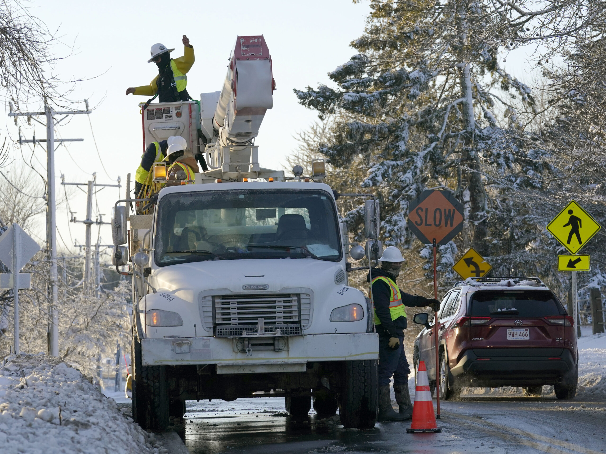 Trucks with cherry pickers help repair damaged power lines, Sunday, Jan. 30, 2022, in Chatham, Mass. An April nor'easter is expected to bring one foot of snow to some places in New England.