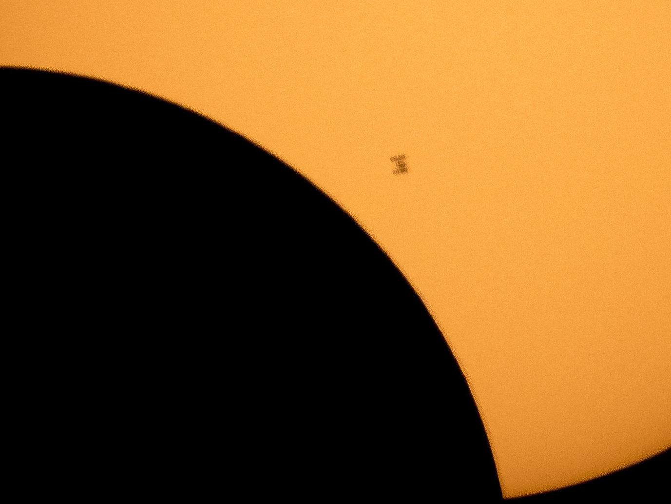 In this image made available by NASA, the International Space Station is silhouetted against the sun during a solar eclipse Monday, Aug. 21, 2017, as seen from Ross Lake, Northern Cascades National Park in Washington state.