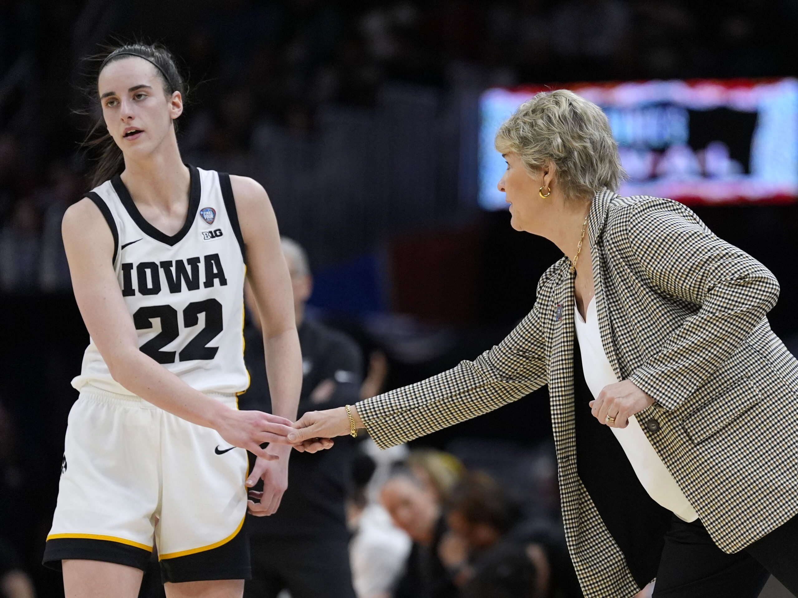 Iowa guard Caitlin Clark (22) with head coach Lisa Bluder during a Final Four college basketball game against UConn in the women's NCAA Tournament, Friday, April 5, 2024, in Cleveland.