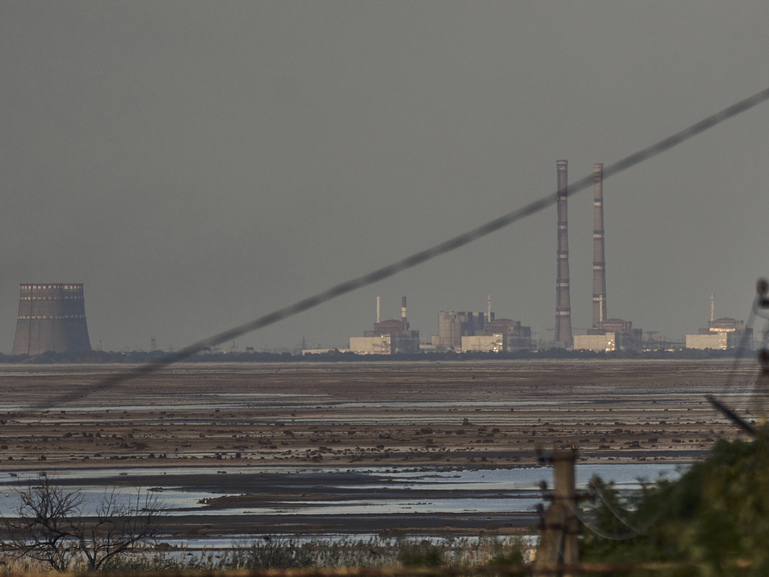 The Zaporizhzhia nuclear power plant, Europe's largest, is seen in the background of the shallow Kakhovka Reservoir after the dam collapse, in Energodar, Russian-occupied Ukraine, Tuesday, June 27, 2023.