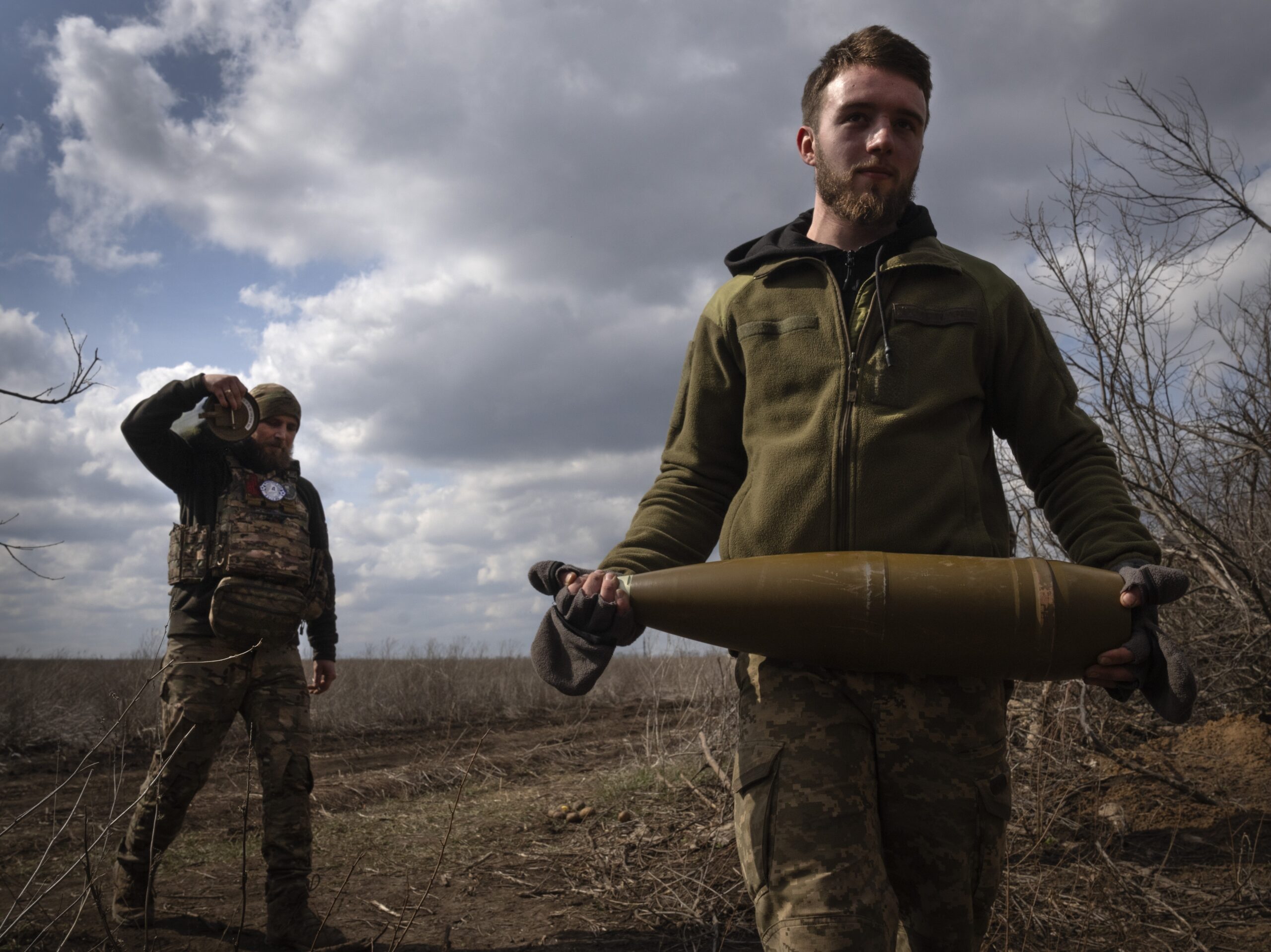 Ukrainian soldiers carry shells to fire at Russian positions on the front line, near the city of Bakhmut, in Ukraine's Donetsk region, on March 25. The outgunned and outnumbered Ukrainian troops have been struggling to halt Russian advances.