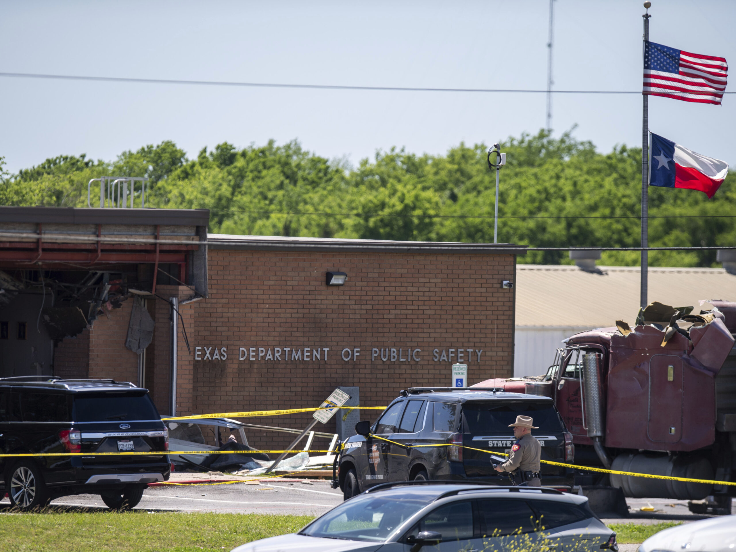Law enforcement personnel work at the scene after a stolen 18-wheeler crashed into a Texas Department of Public Safety office on US-290 in Brenham, Texas on Friday.
