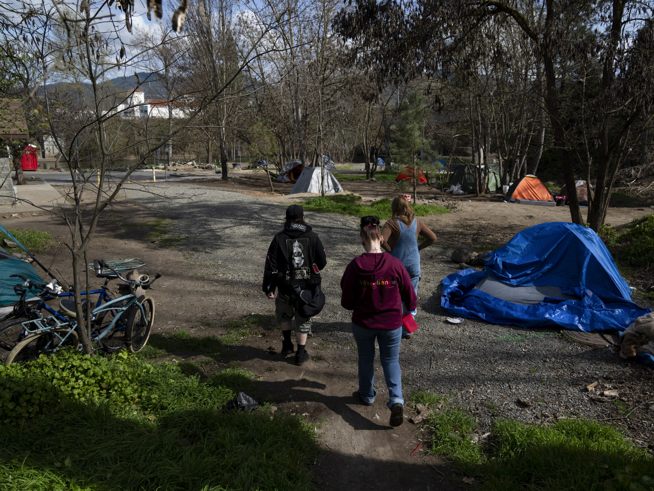 A group of volunteers check on homeless people living in a park in Grants Pass, Ore., on March 21.