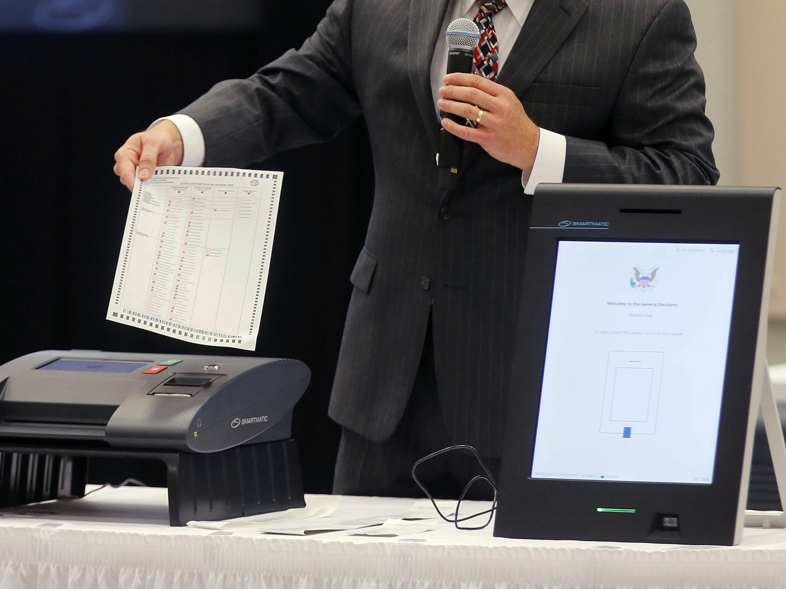 A Smartmatic representative demonstrates his company's system, which has scanners and touch screens with printout options, at a meeting of the Secure, Accessible & Fair Elections Commission, on Aug. 30, 2018, in Grovetown, Ga.