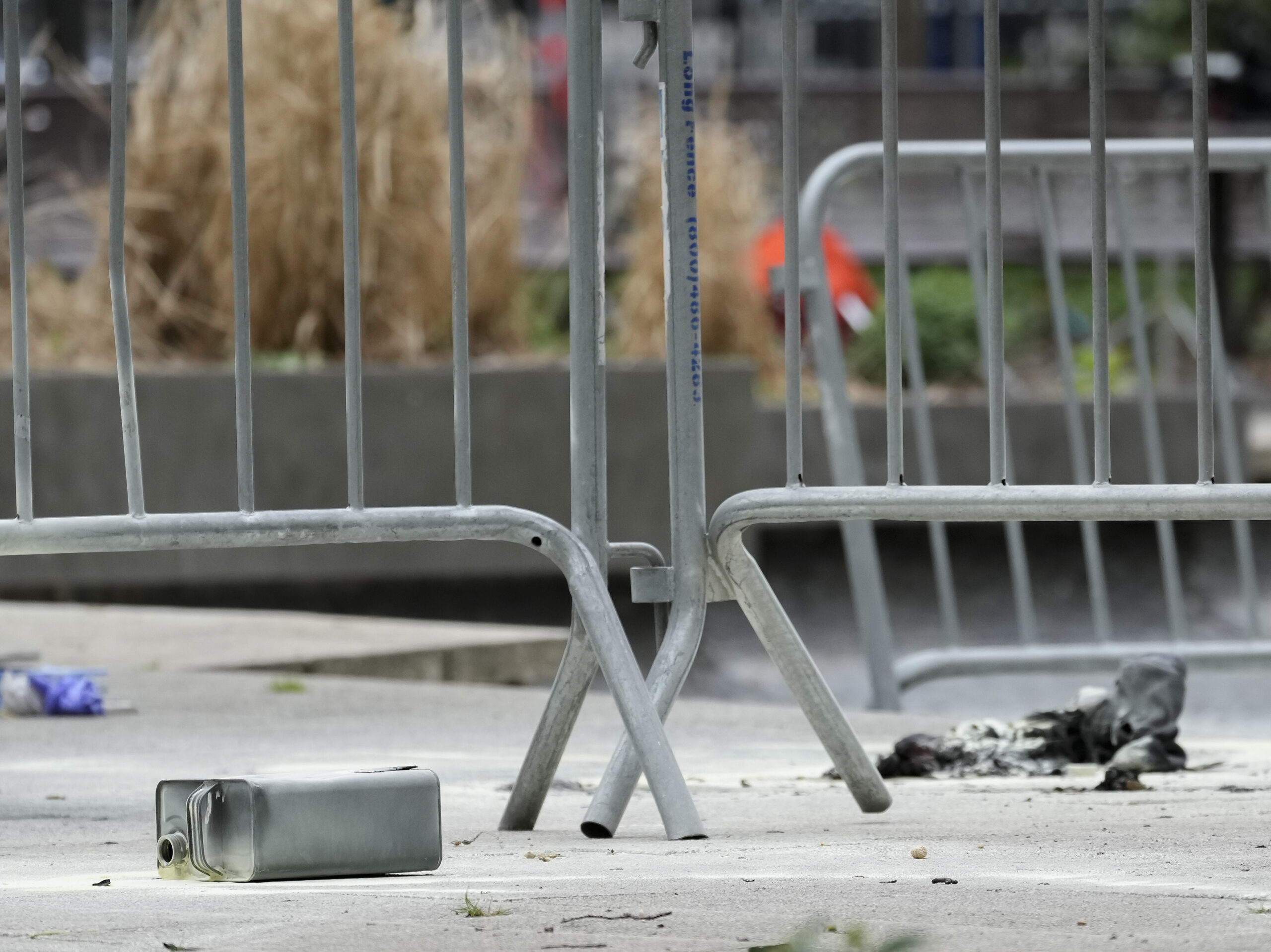 A metal can sits on the ground at the scene where a man lit himself on fire in a park outside Manhattan criminal court on Friday in New York.